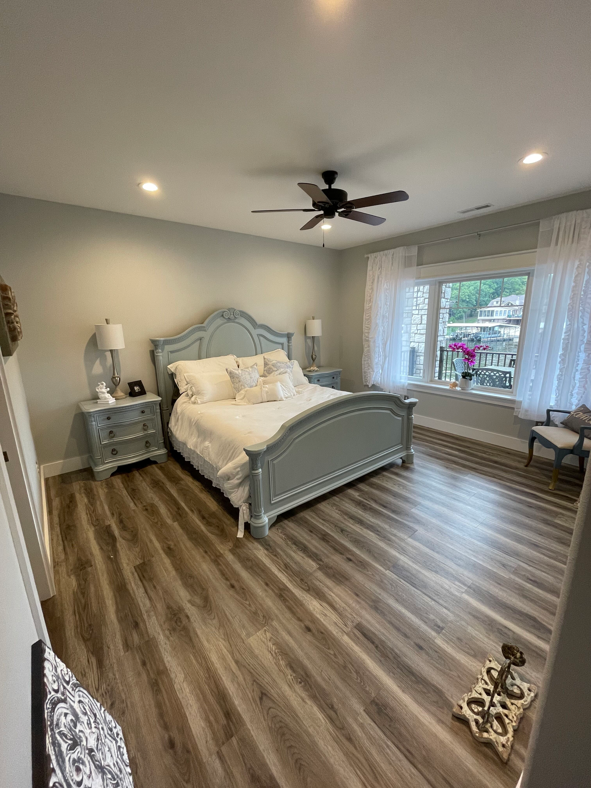 A bedroom with a bed , nightstands , and a ceiling fan.