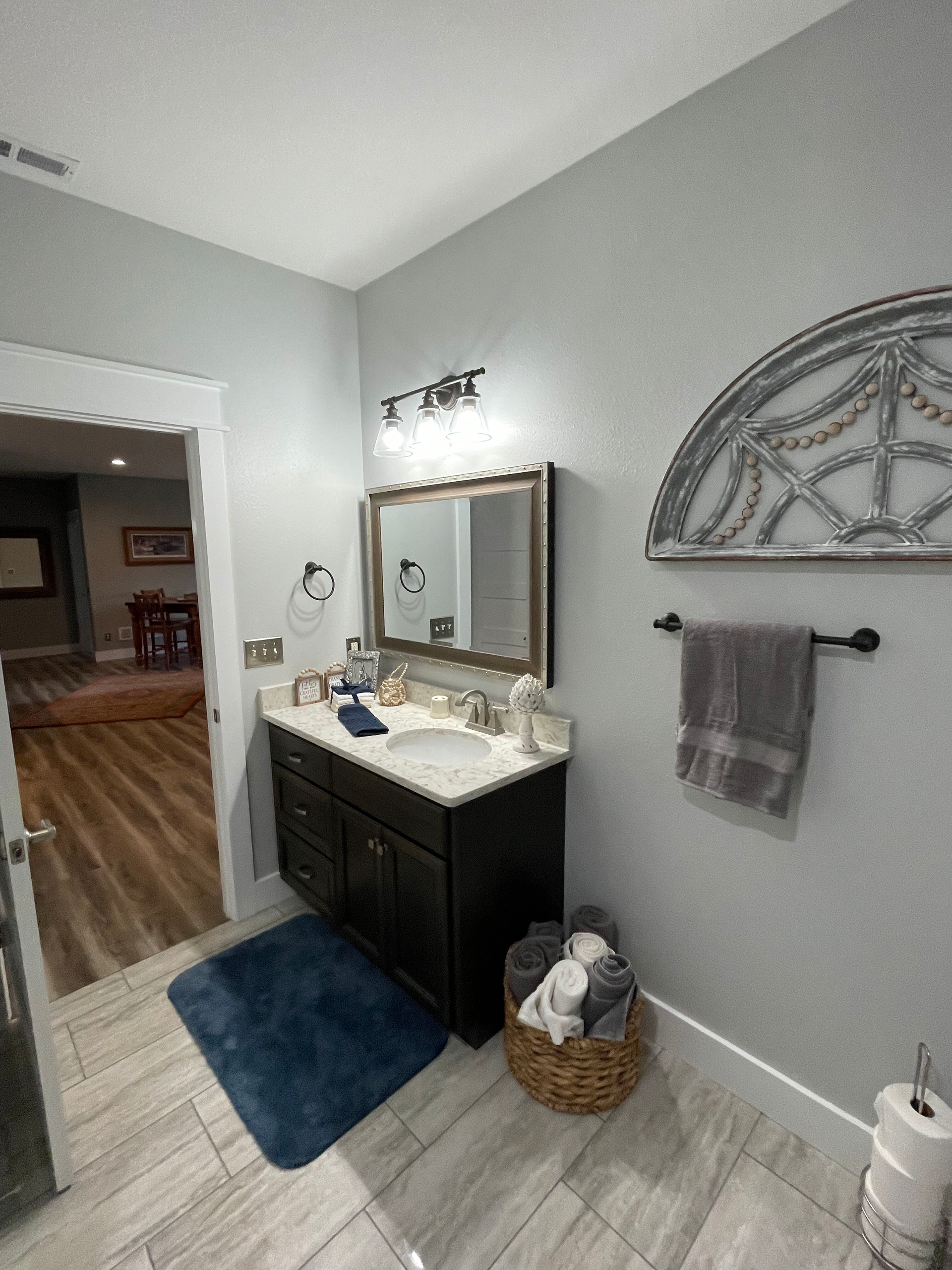 A bathroom with a sink , mirror , and towel rack.