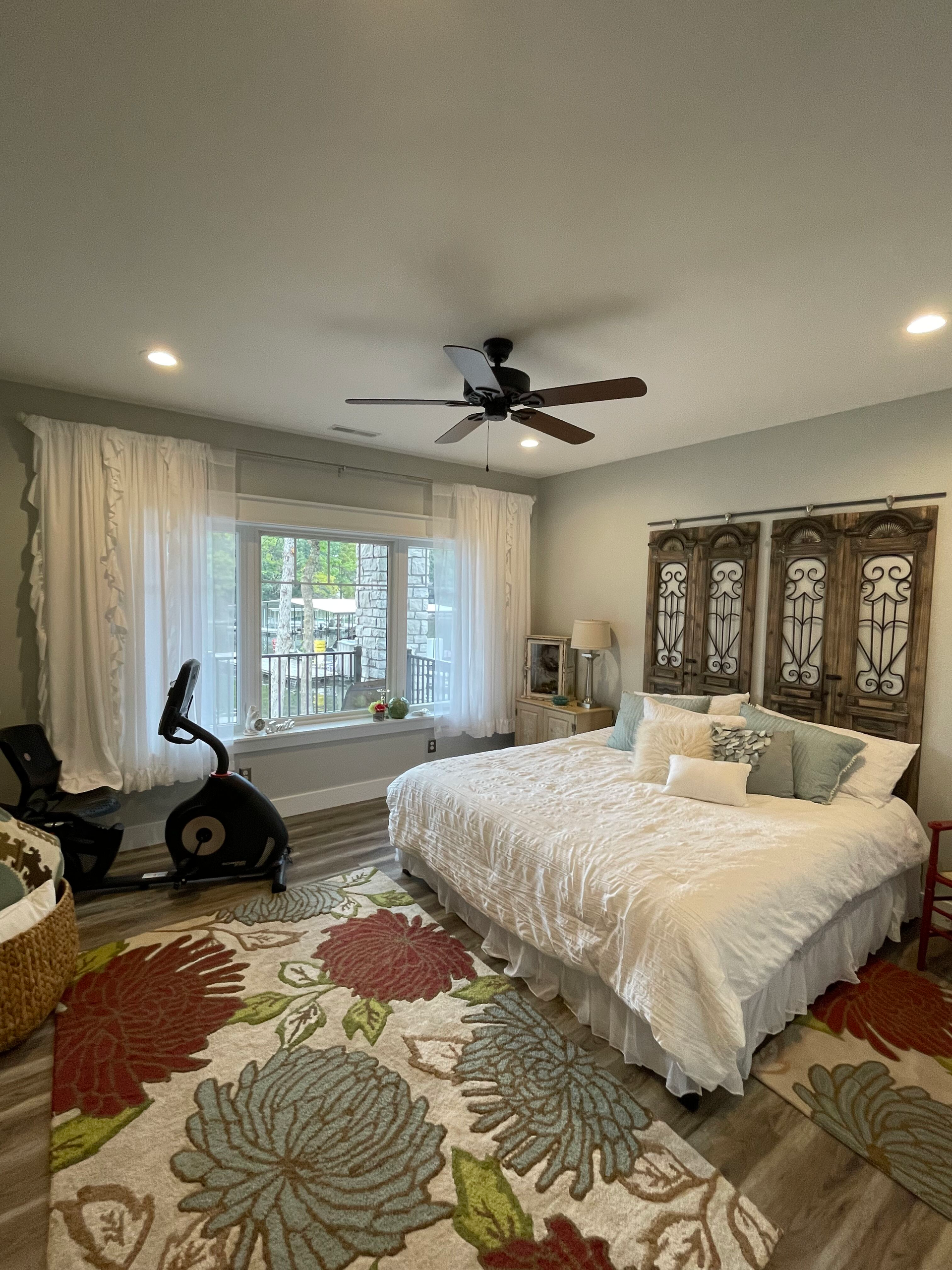 A bedroom with a large bed and a ceiling fan.