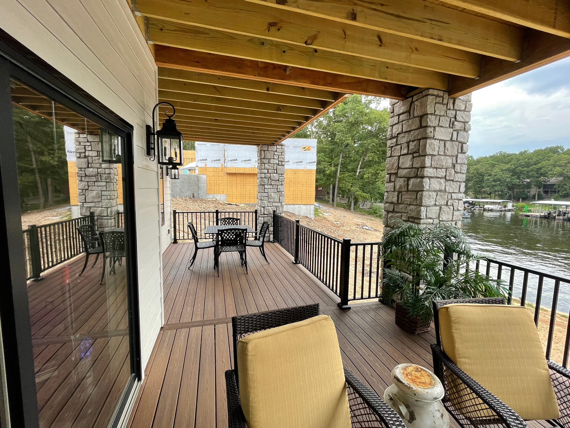 A large deck with a table and chairs overlooking a lake.