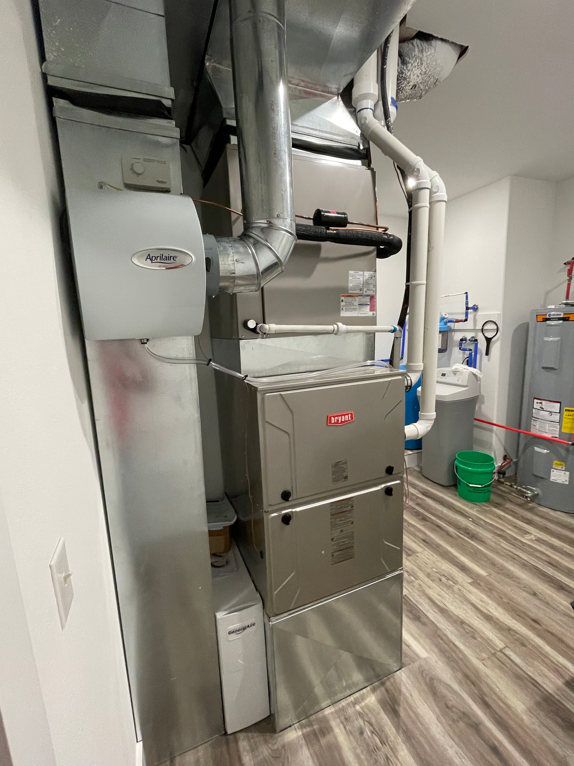 A stainless steel furnace is sitting in a room next to a wall.