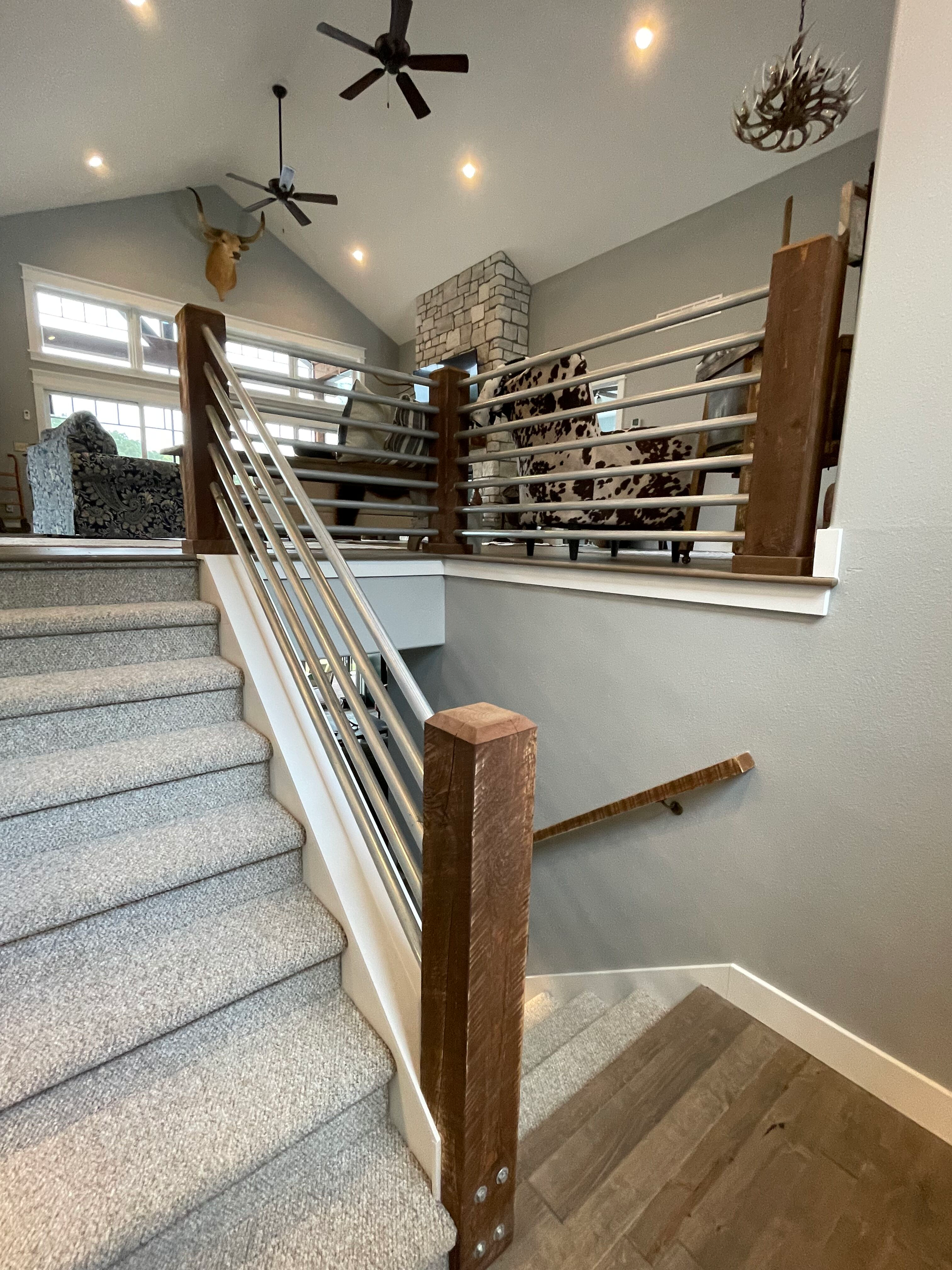 A staircase in a house with a wooden railing and a ceiling fan.