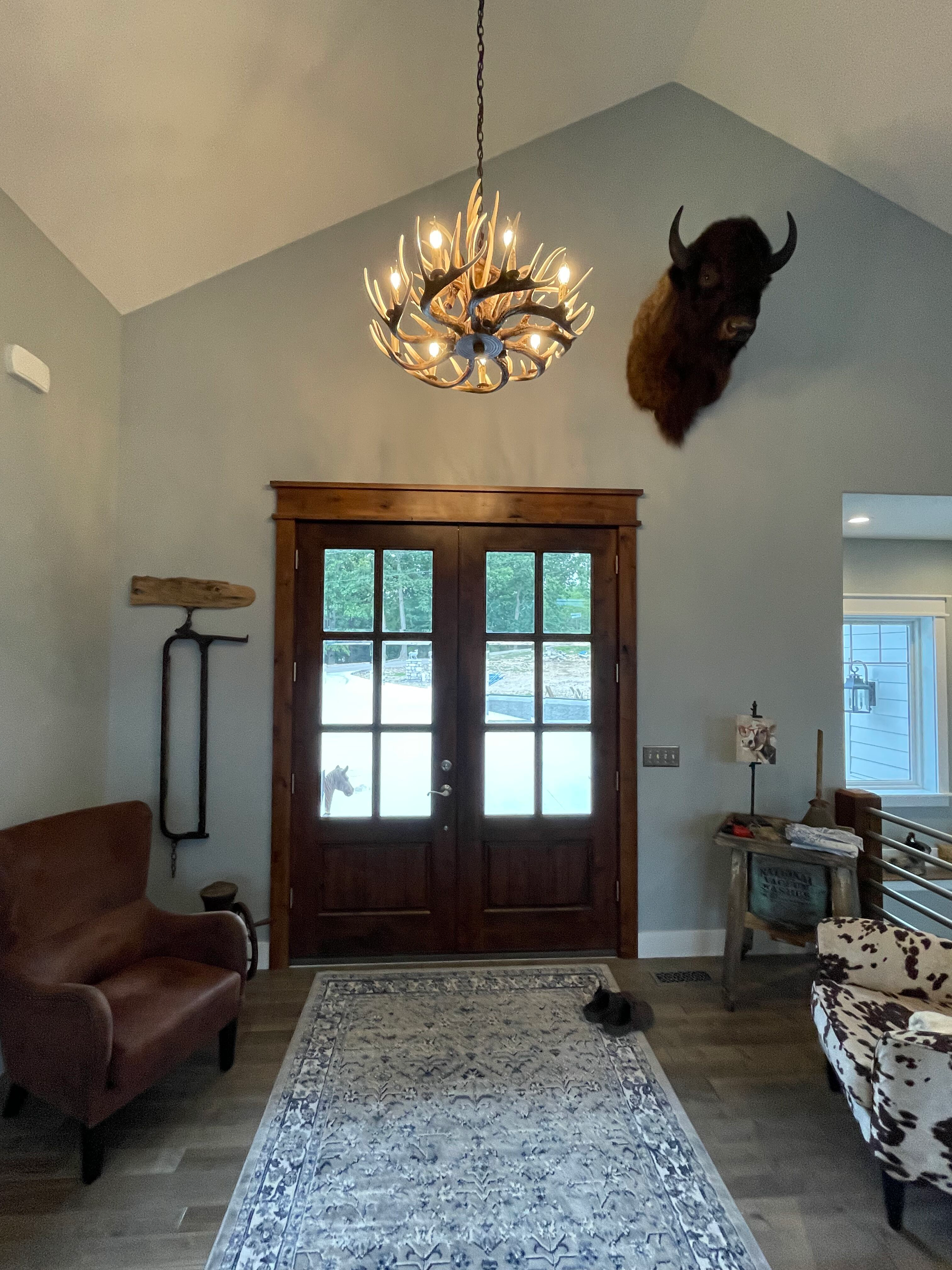 A living room with a chandelier hanging from the ceiling