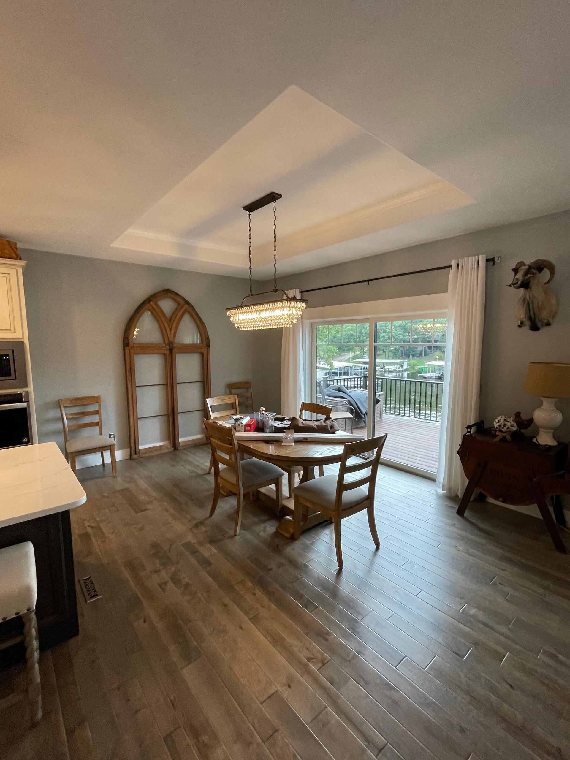 A dining room with a table and chairs and a large window