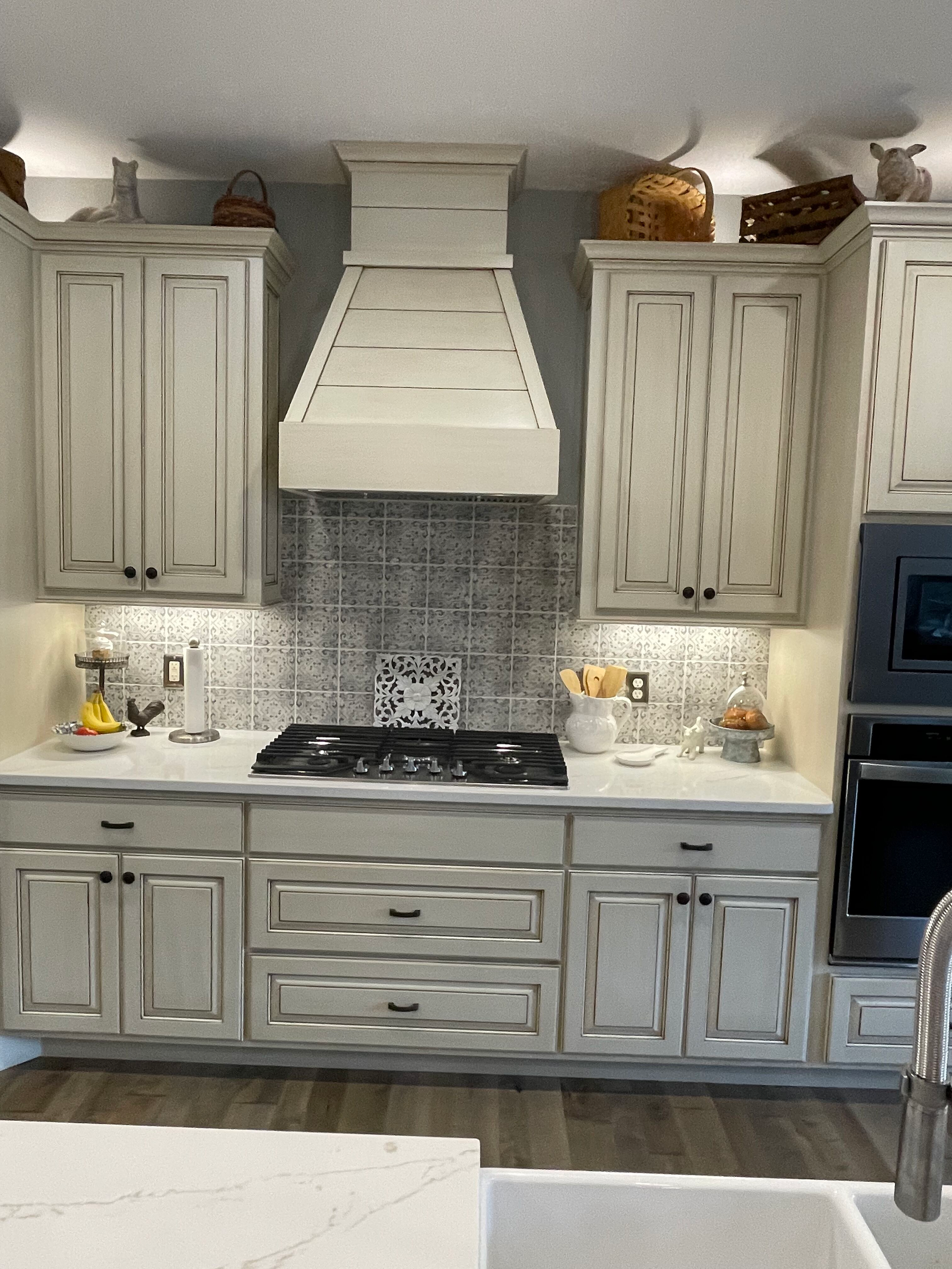 A kitchen with white cabinets and a stove top oven