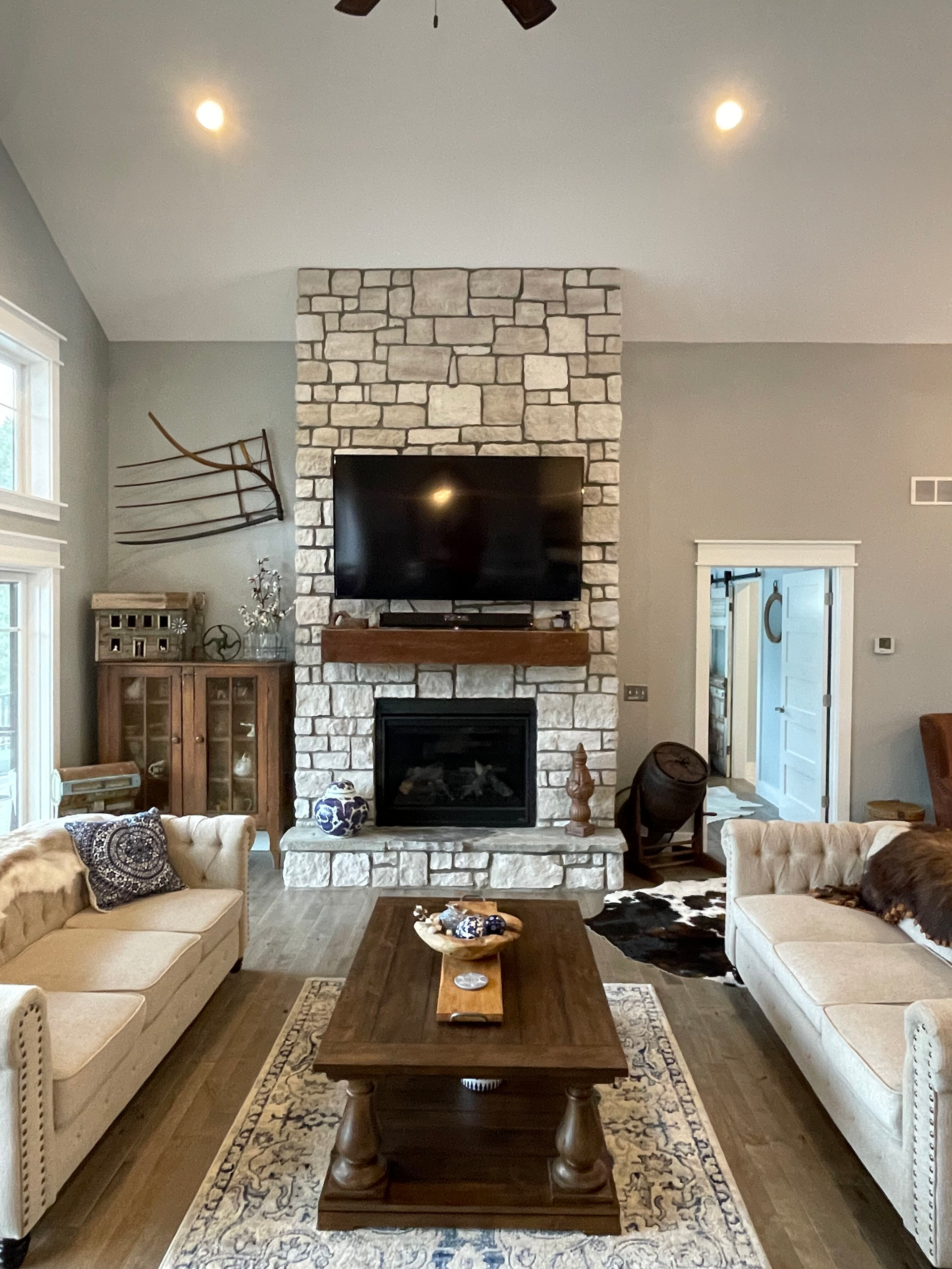 A living room with a fireplace , couch , coffee table and television.