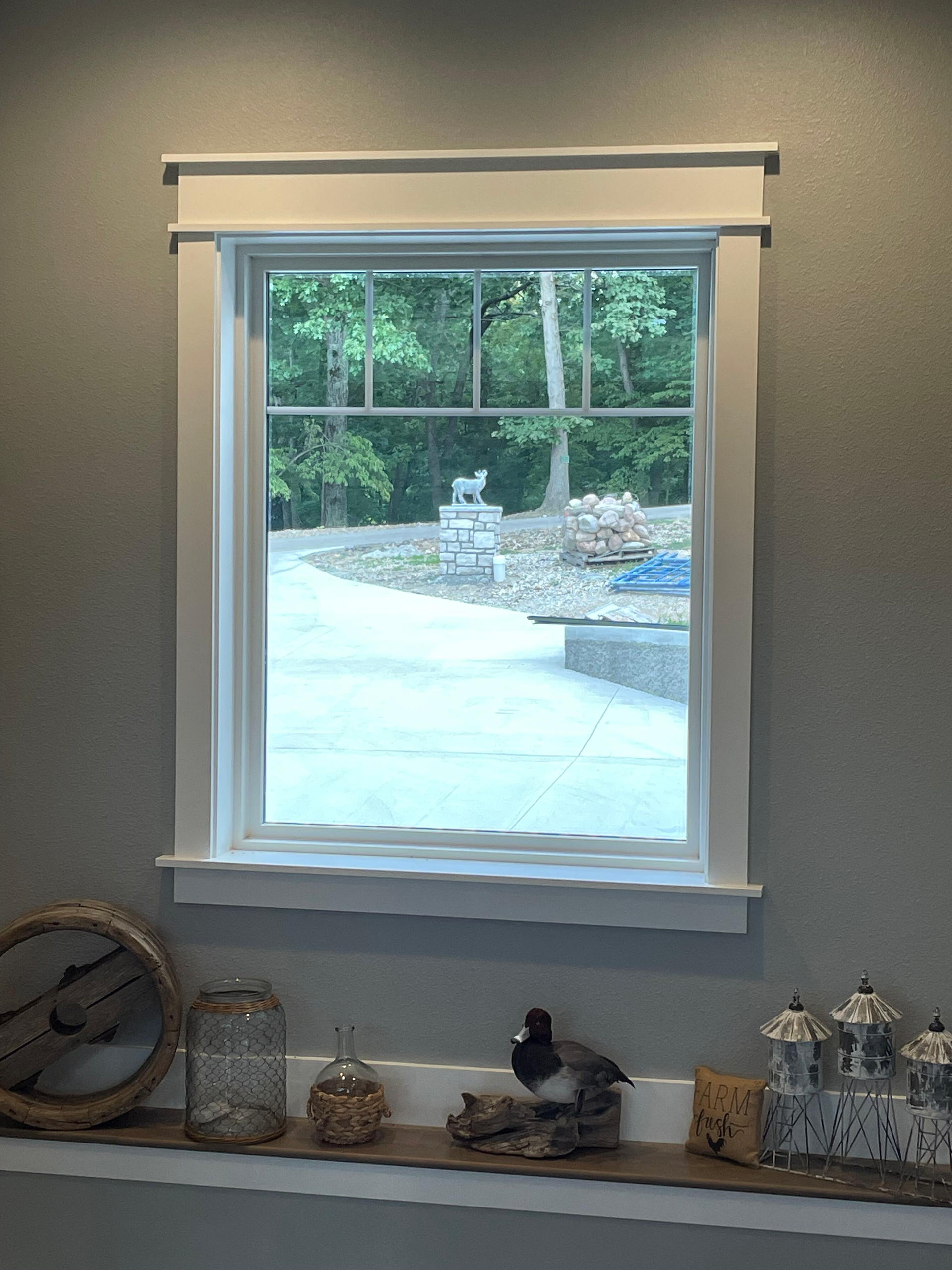 A window with a white frame is sitting on a shelf in a room.