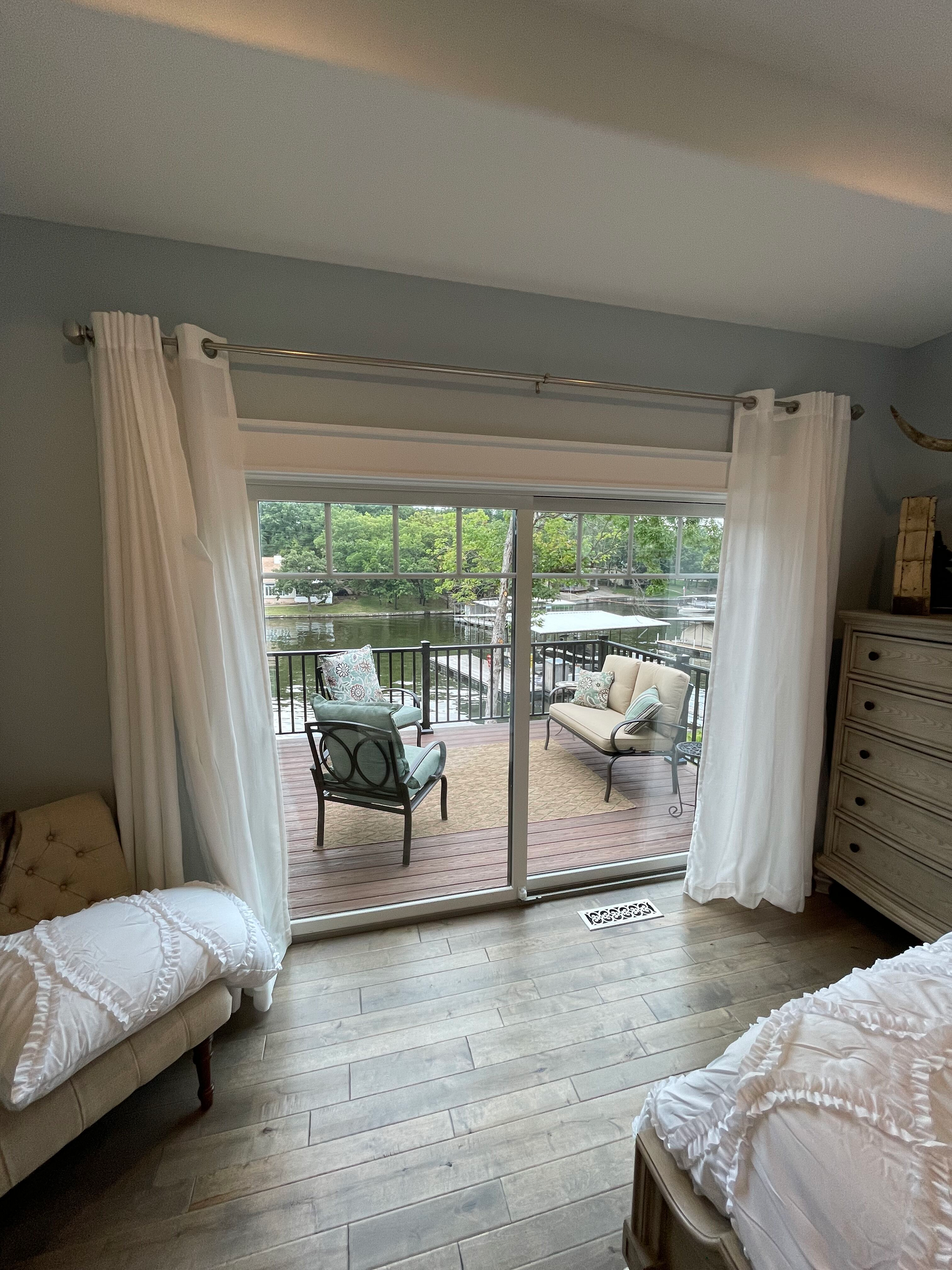 A bedroom with a sliding glass door leading to a balcony.