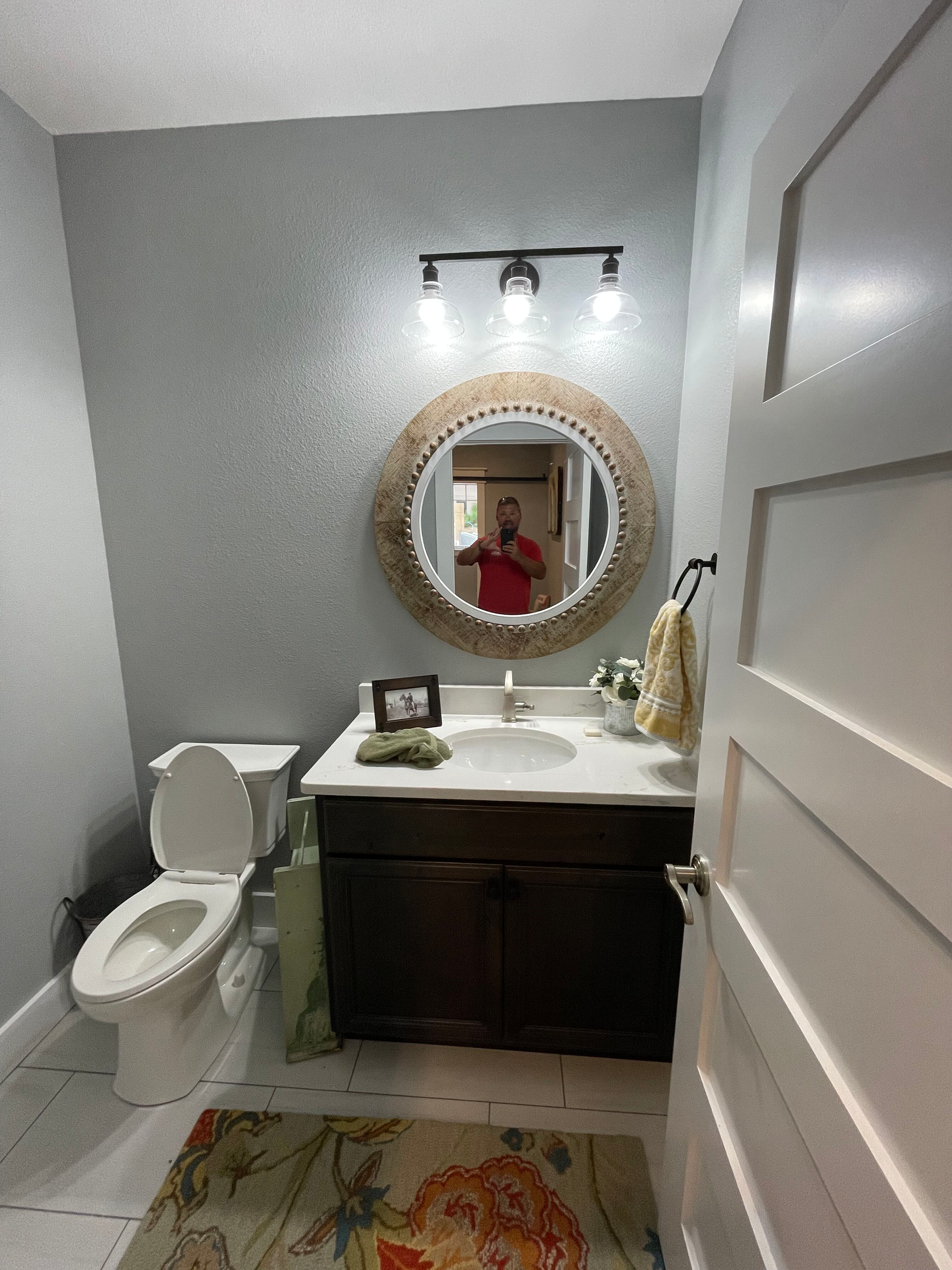 A bathroom with a toilet , sink , and mirror.