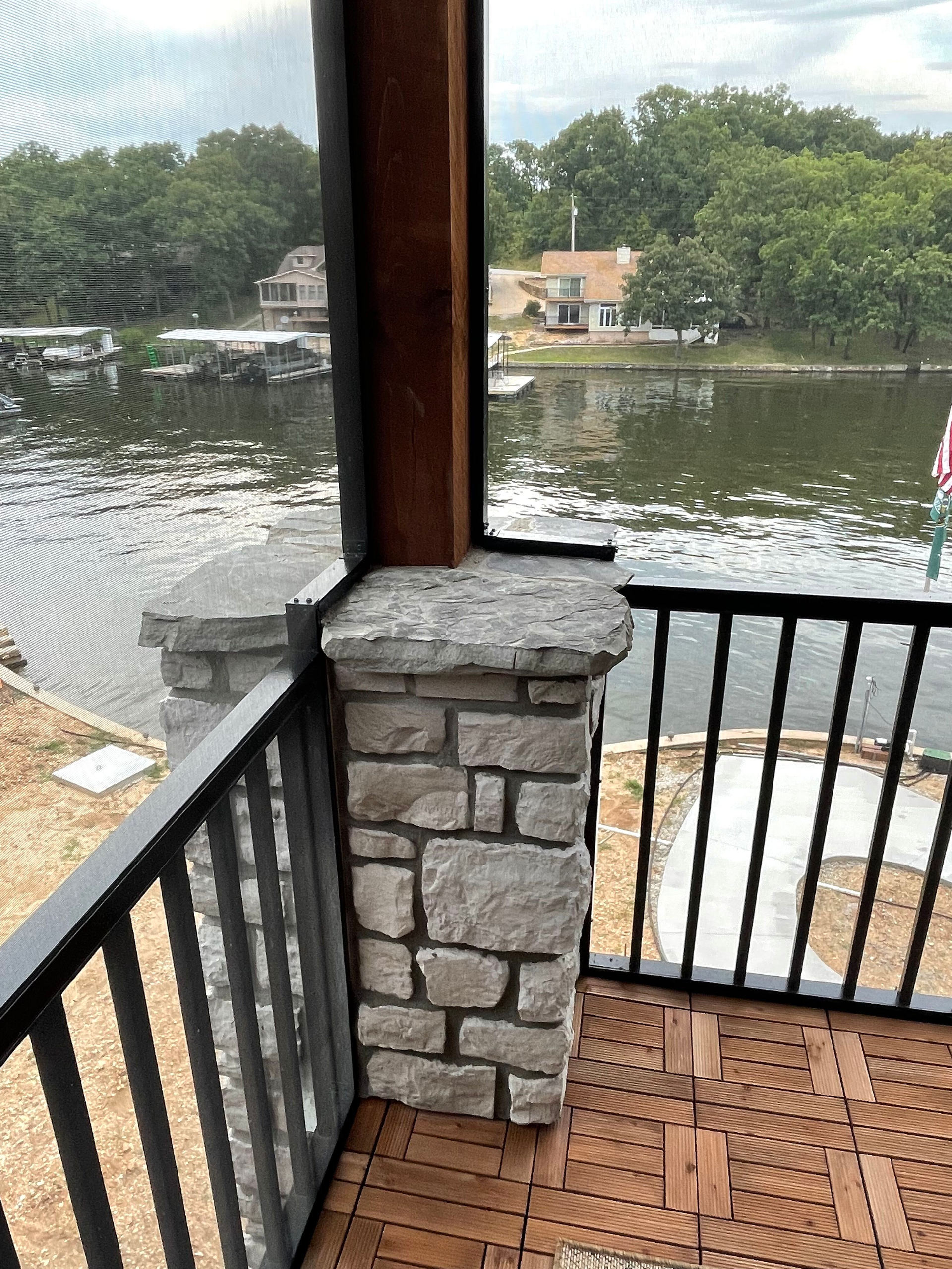 A screened in porch with a view of a lake.