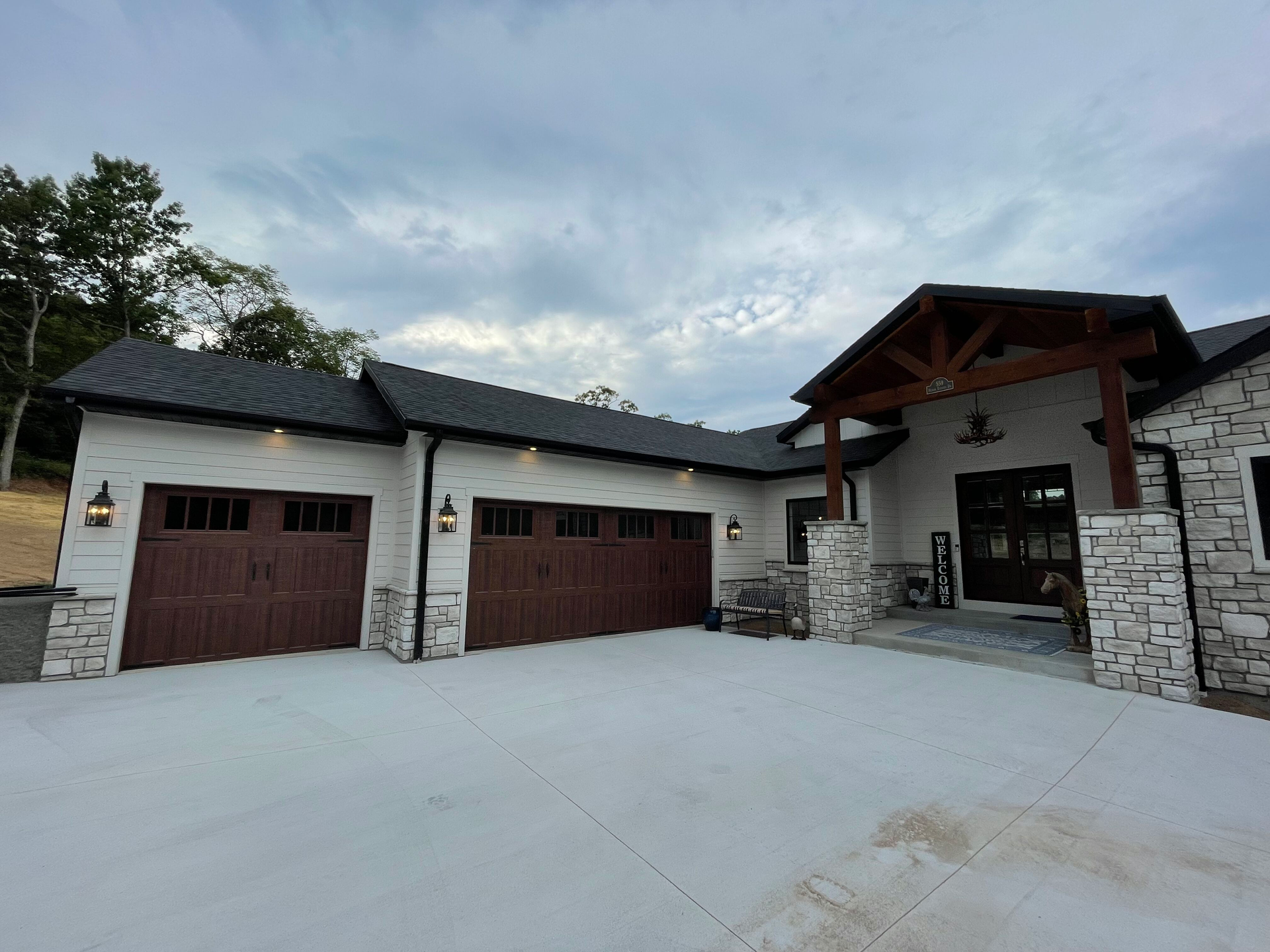 A large house with three garage doors and a large driveway.