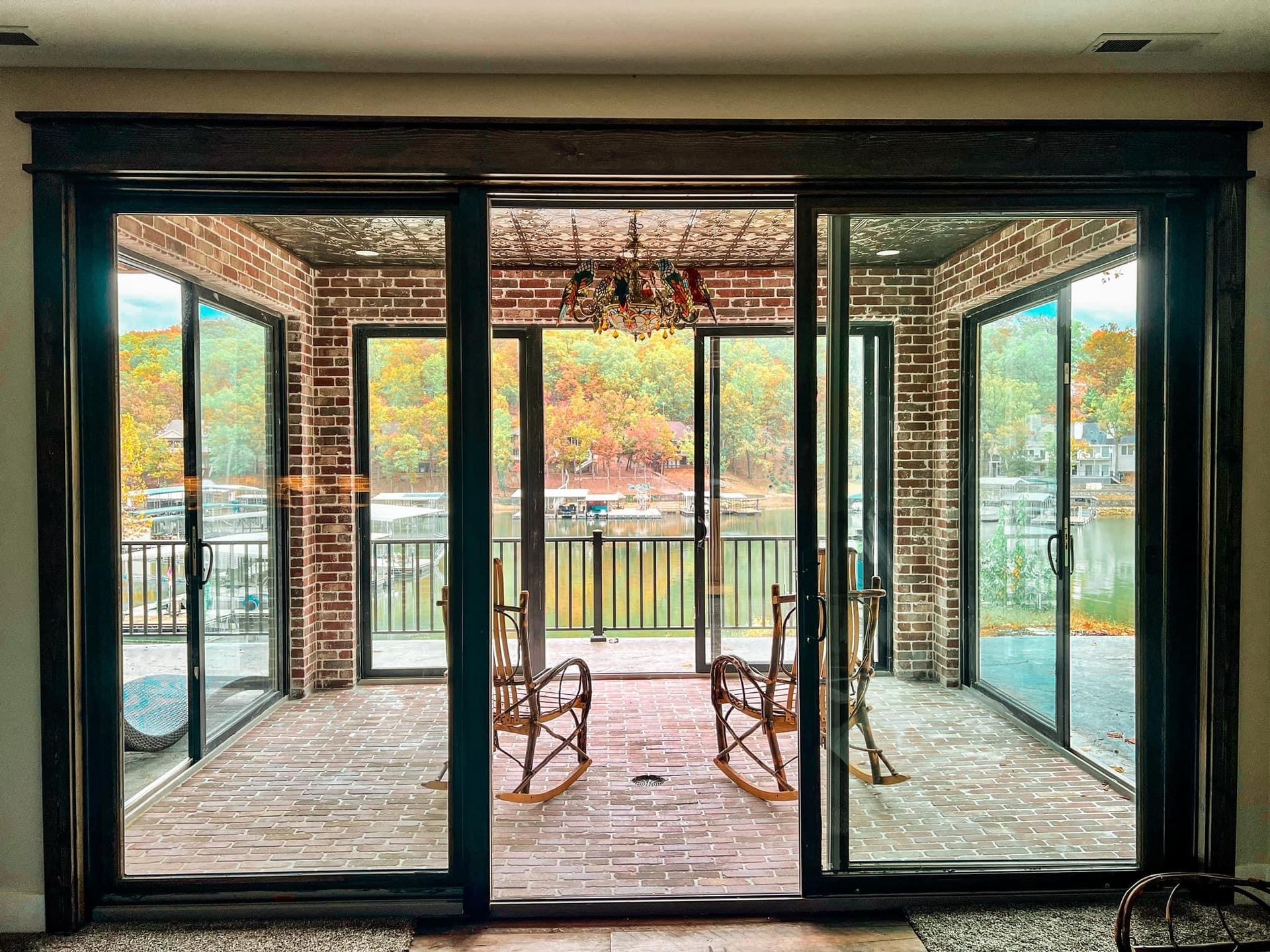 A room with a lot of windows and rocking chairs.