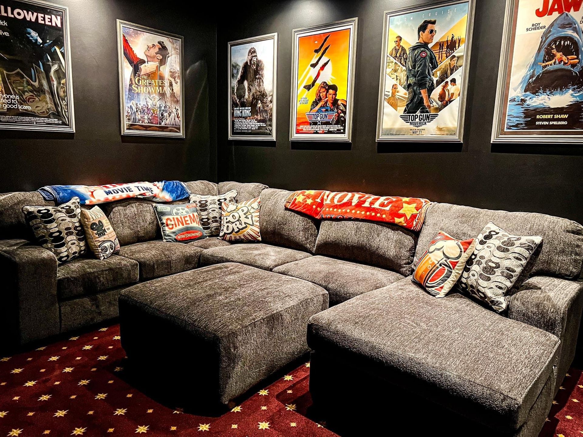 A movie theater with a couch and posters on the wall