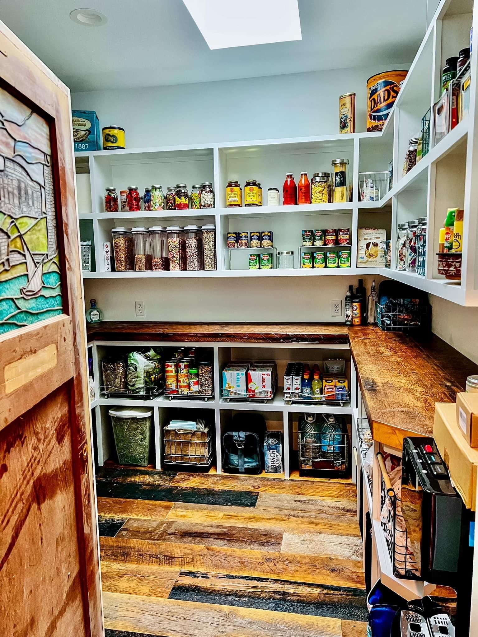 A pantry filled with lots of food and a stained glass door.