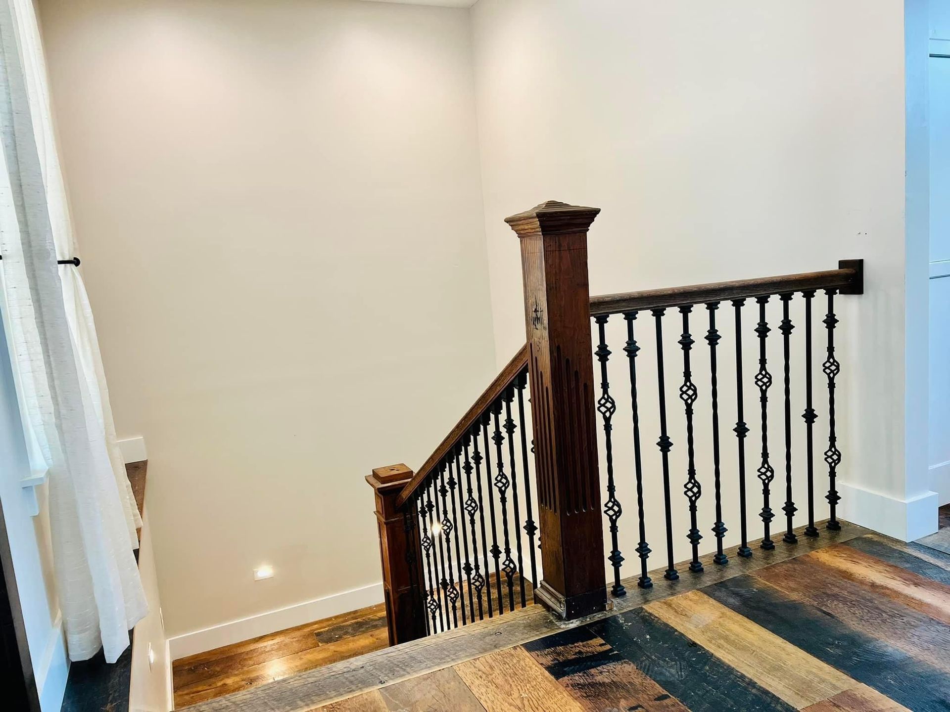 A staircase with a wooden railing and a metal railing in a house.
