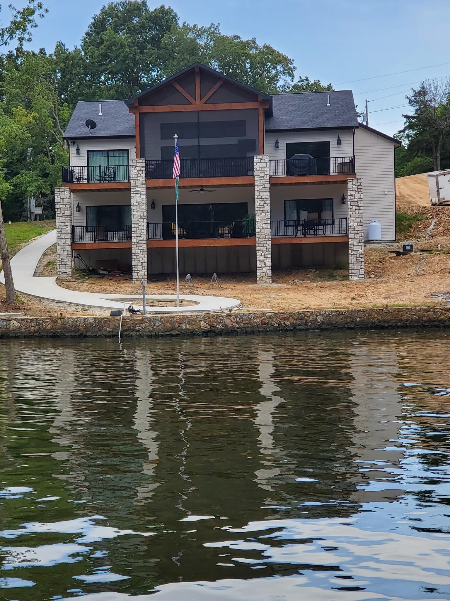 A large house sits on the shore of a lake