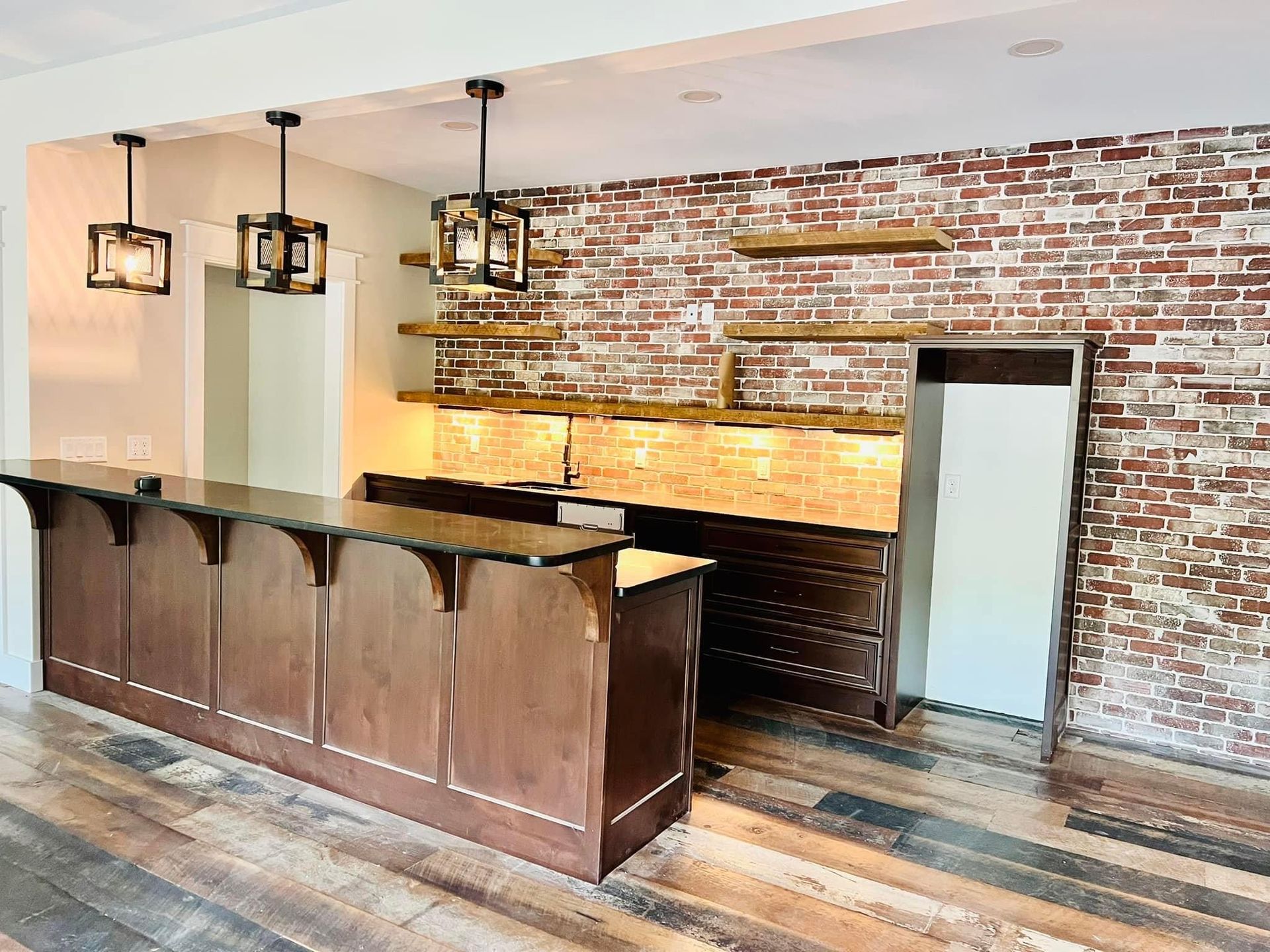 A kitchen with a brick wall and a wooden counter top.