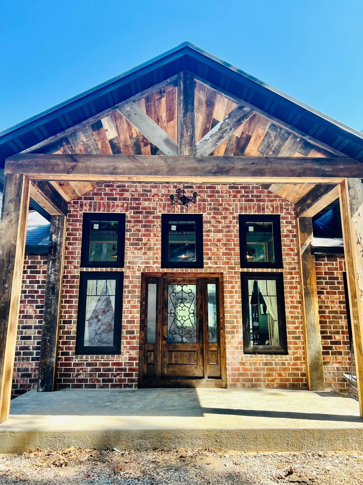 A brick building with a wooden roof and a porch