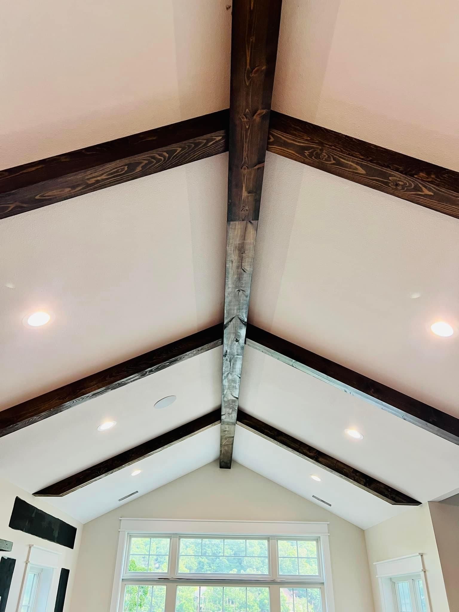 A living room with a vaulted ceiling and wooden beams.