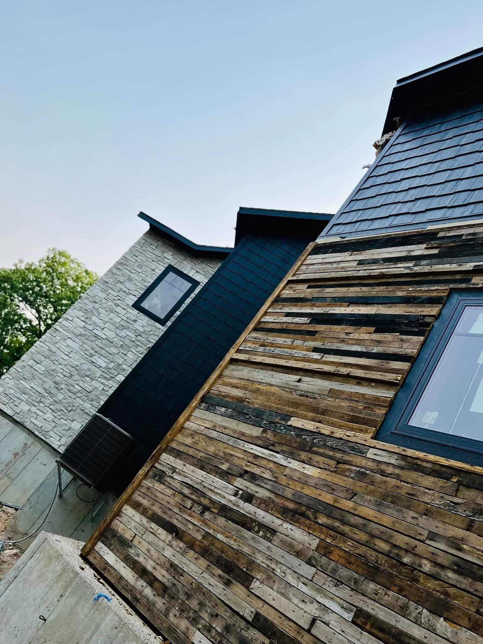 A house with a wooden siding and a black roof.