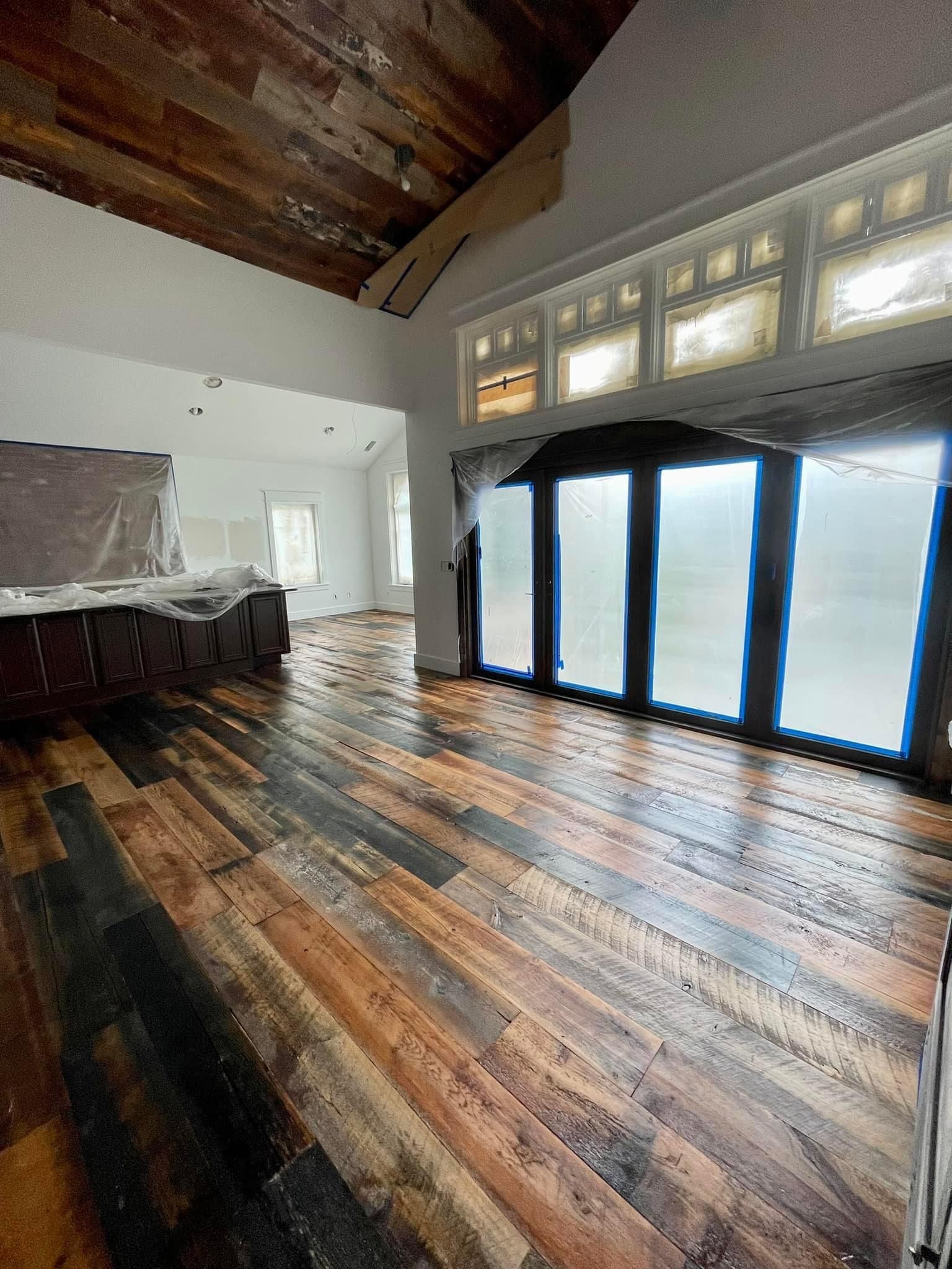 A large room with a wooden floor and lots of windows.