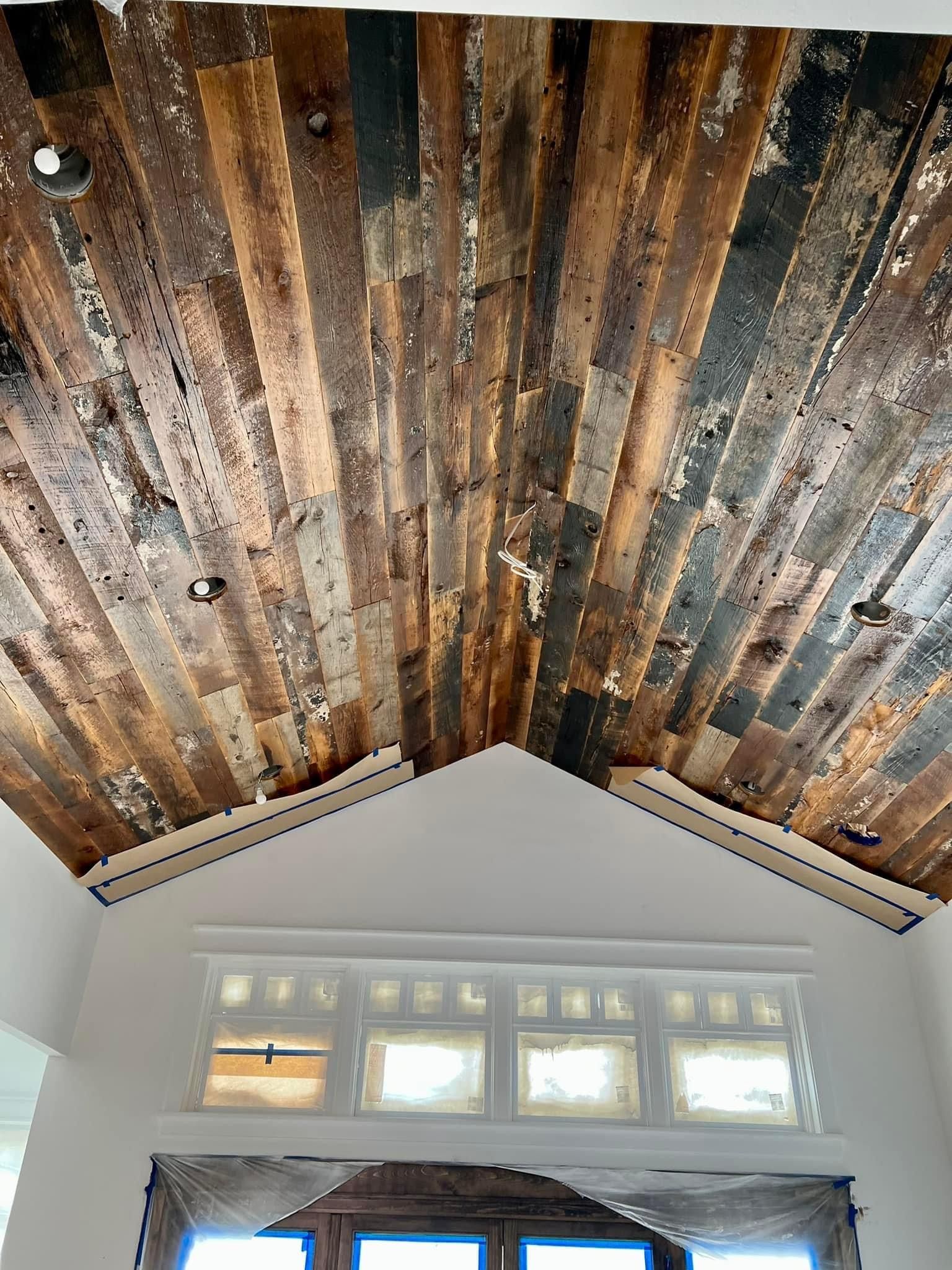 A wooden ceiling with a vaulted ceiling in a living room.