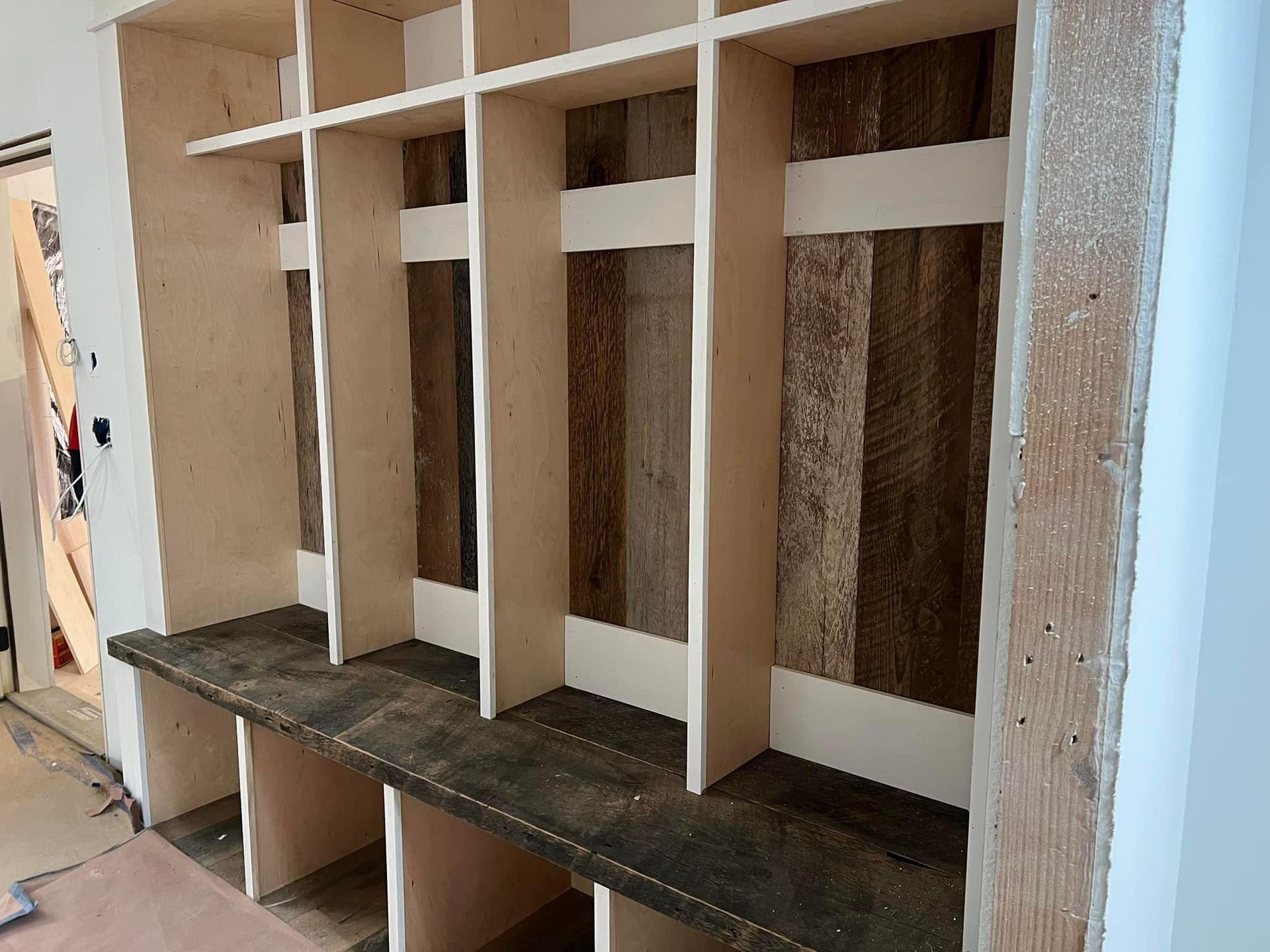 A room with a row of wooden shelves and benches.