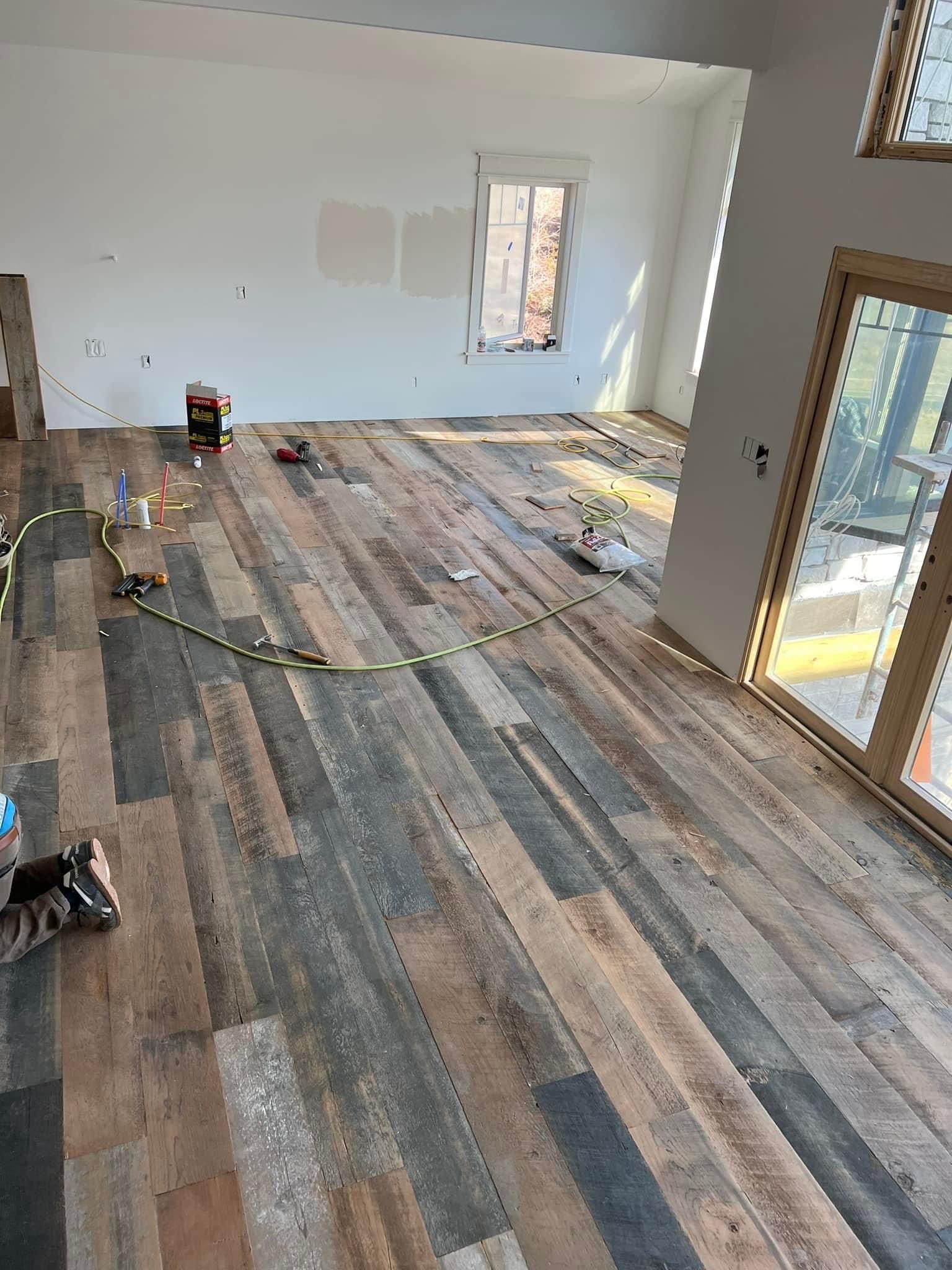 A living room with a wooden floor and sliding glass doors.