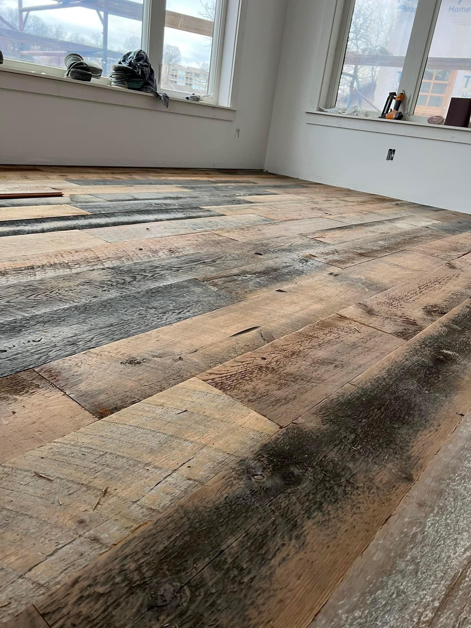 A room with a wooden floor and a lot of windows.