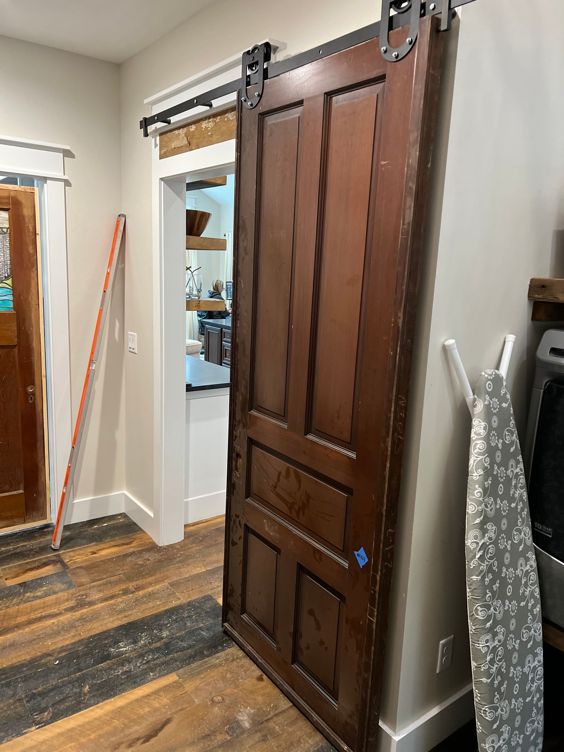 A wooden sliding barn door is open in a room.