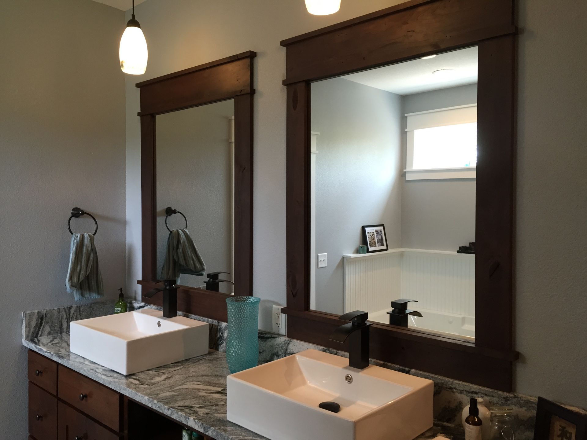 A bathroom with two sinks and two mirrors