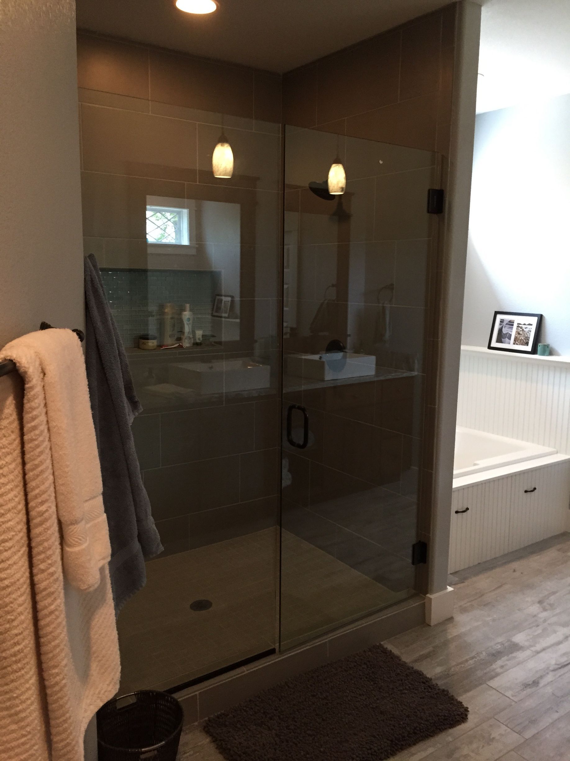 A bathroom with a walk in shower and a bathtub.