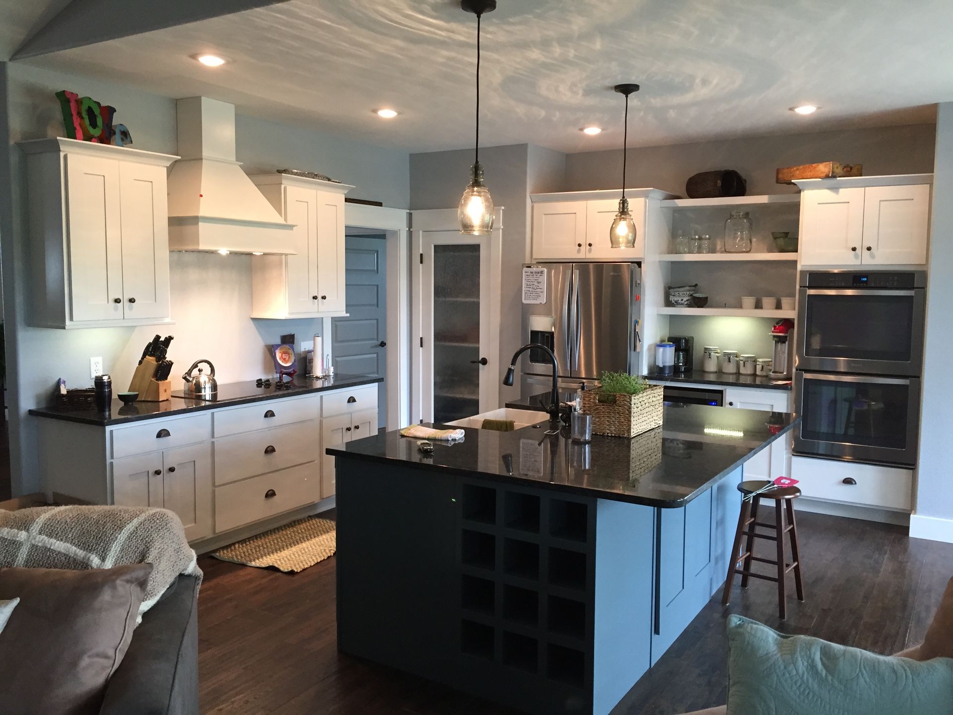 A kitchen with white cabinets and black counter tops
