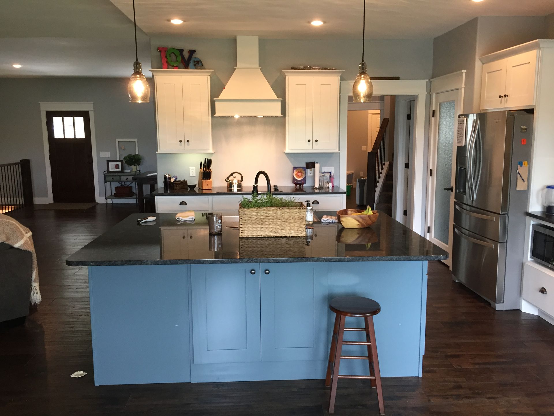 A kitchen with blue cabinets and a black counter top.
