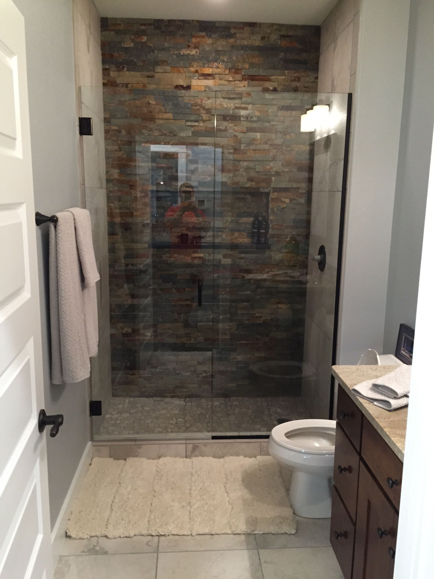 A bathroom with a walk in shower and a toilet.