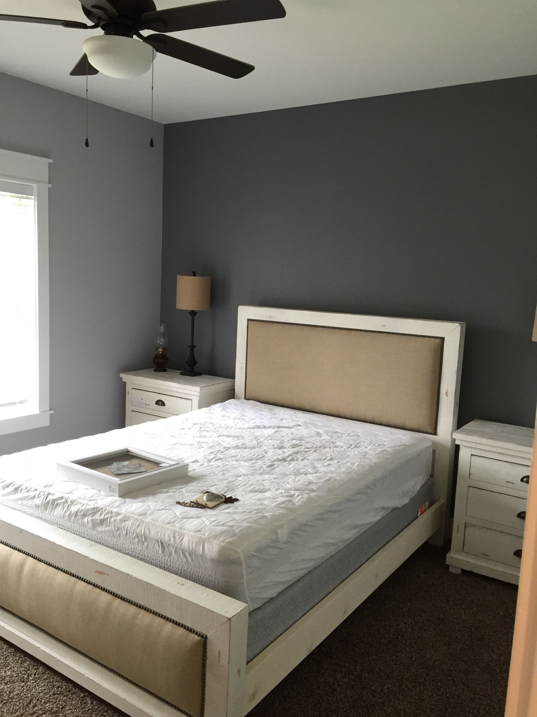 A bedroom with a bed and a ceiling fan