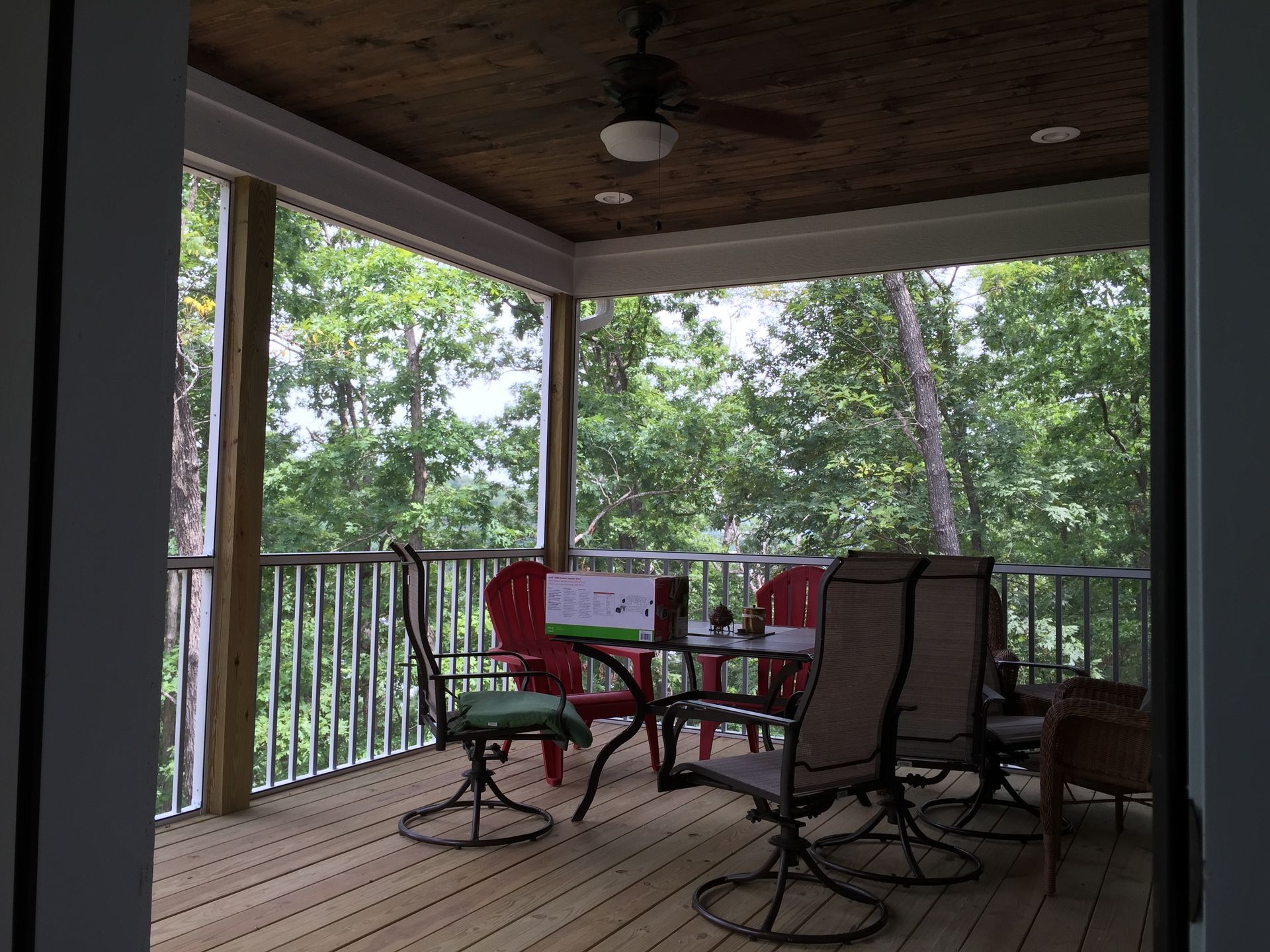 A porch with a table and chairs and a ceiling fan