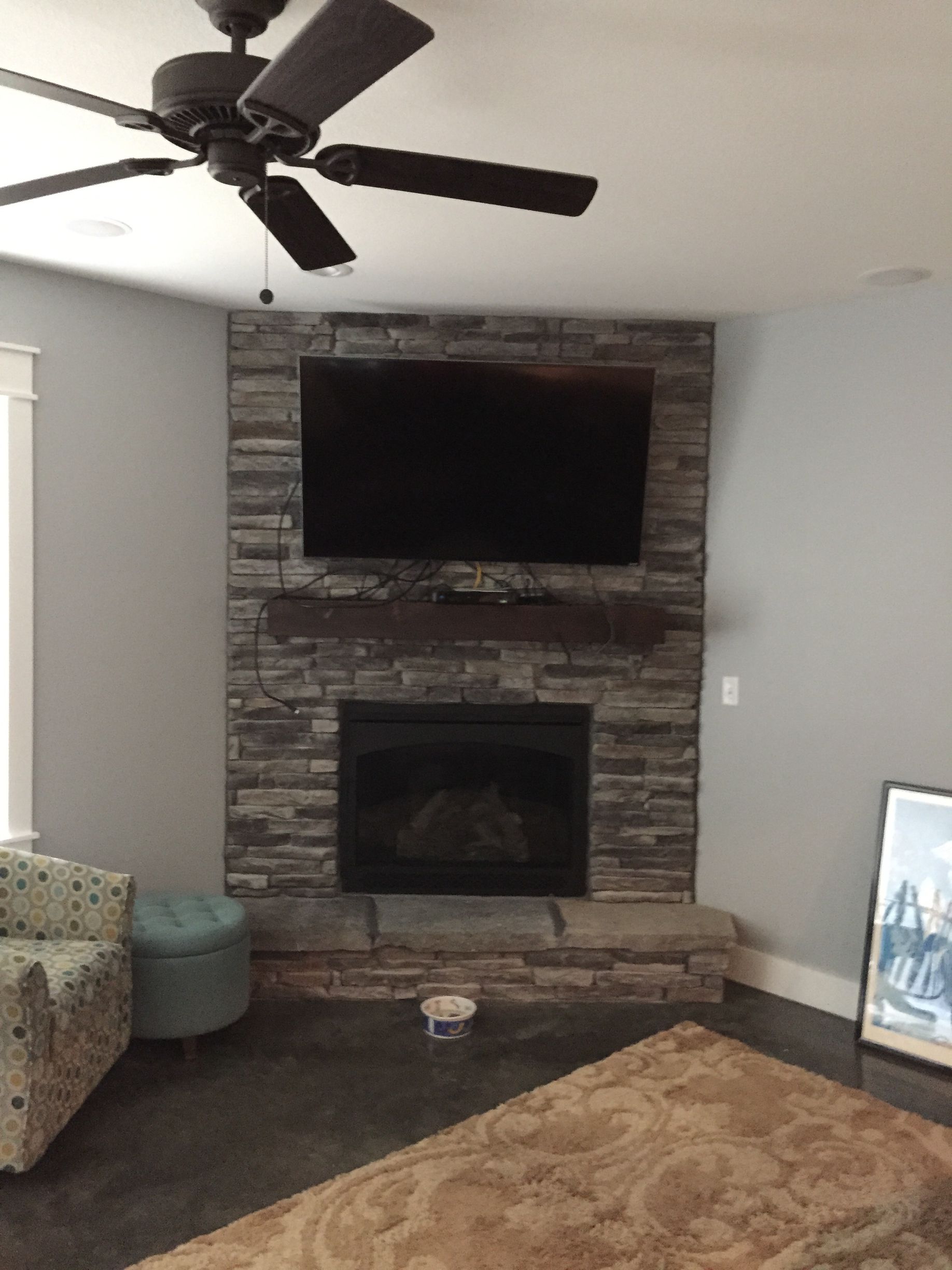 A living room with a fireplace and a flat screen tv on the wall.
