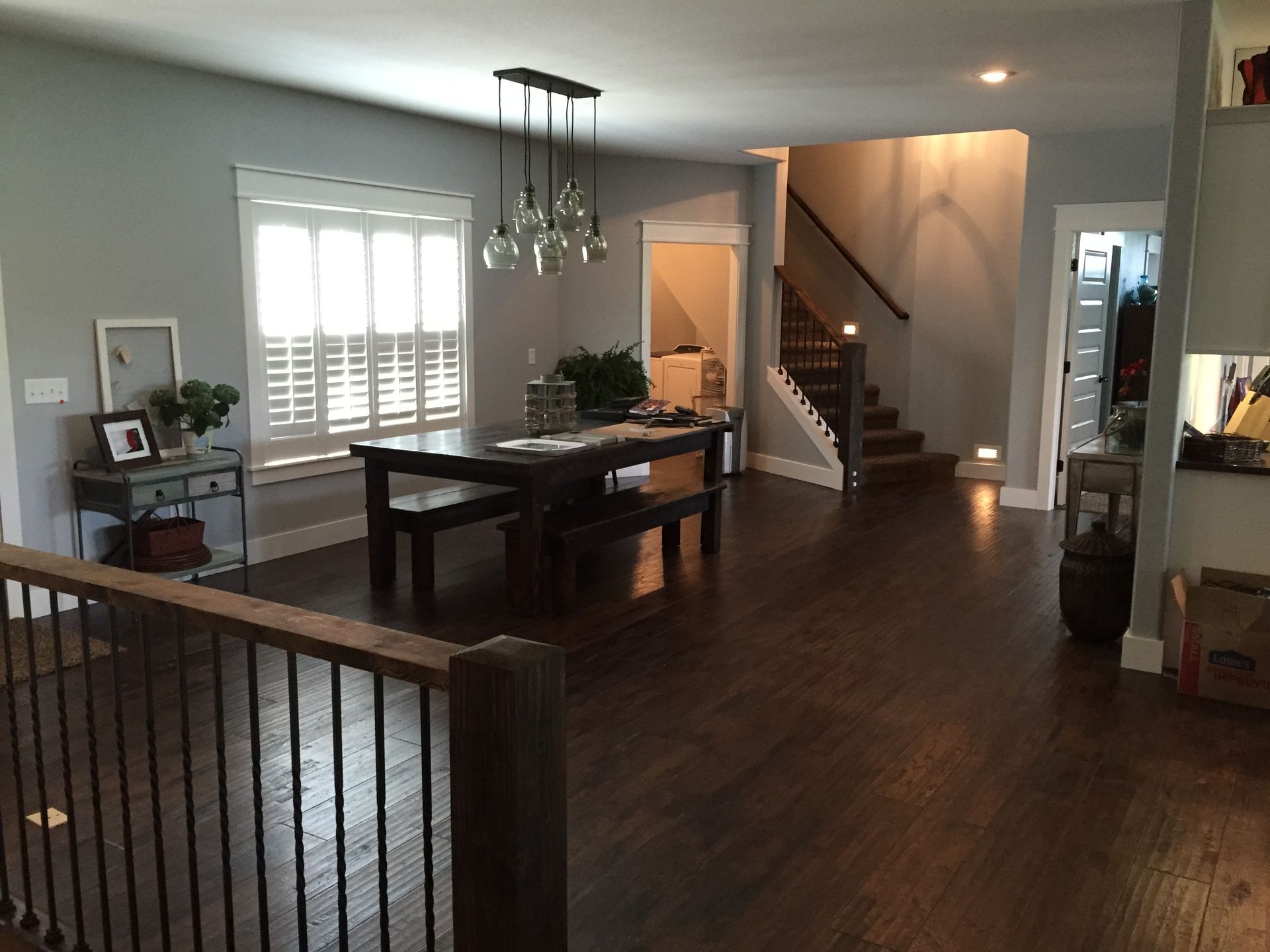 A dining room with a table and benches and stairs