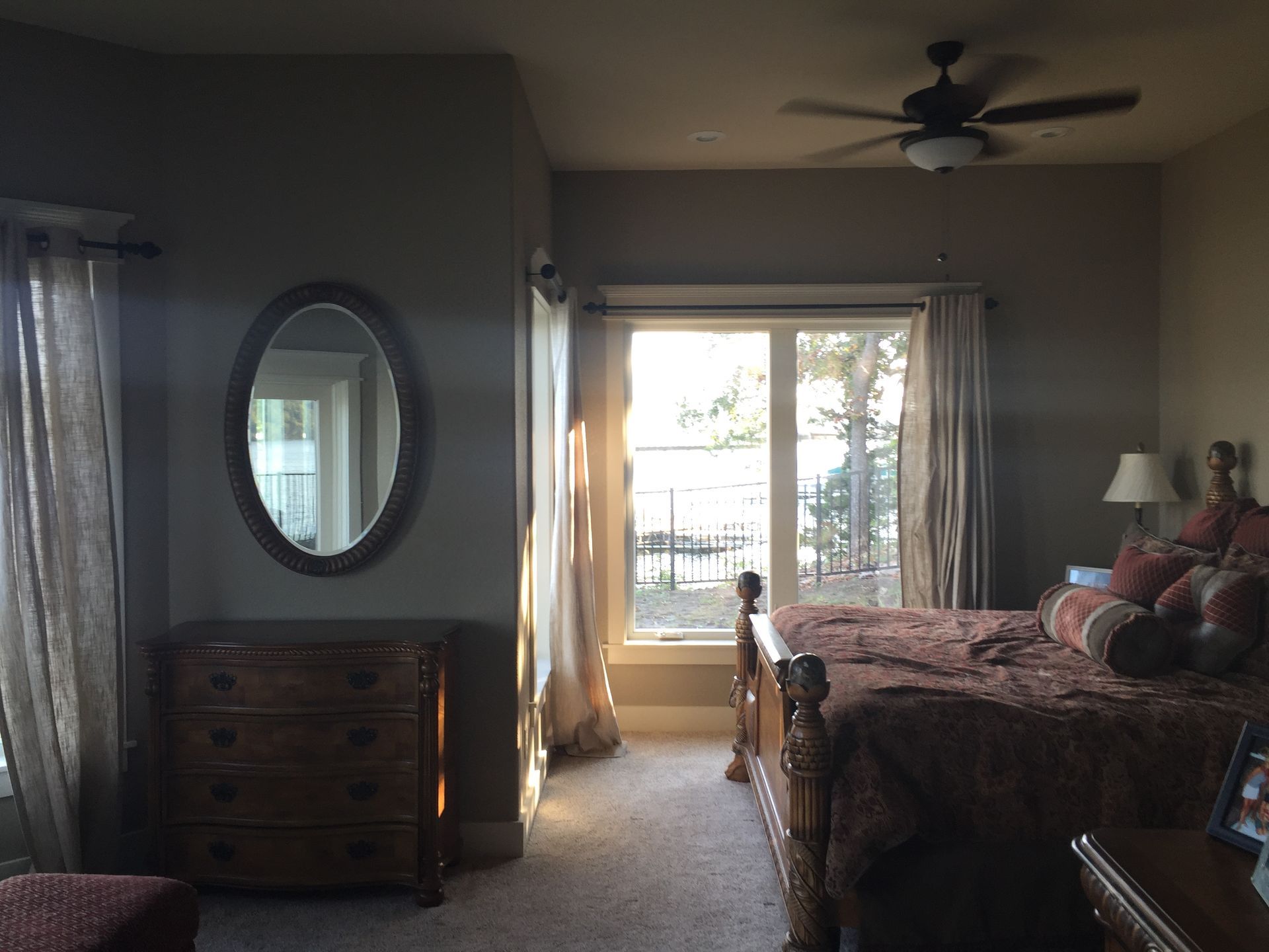 A bedroom with a large bed and a ceiling fan