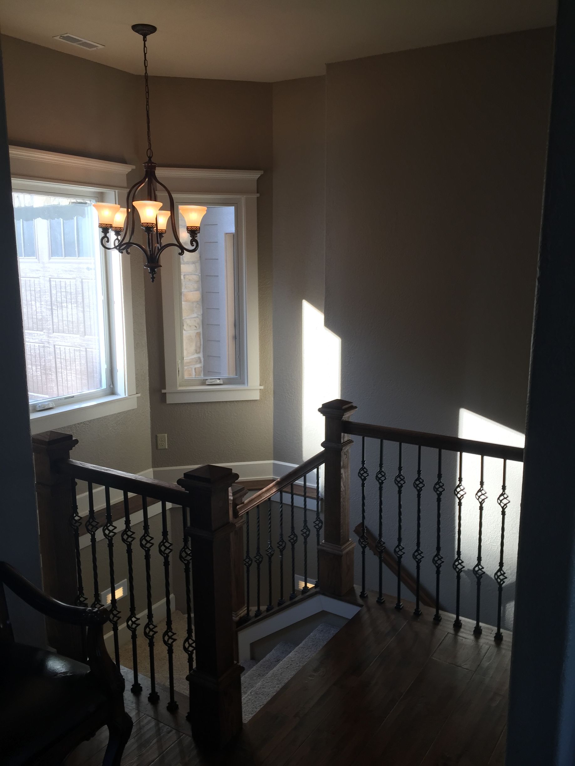 A staircase with a chandelier hanging from the ceiling
