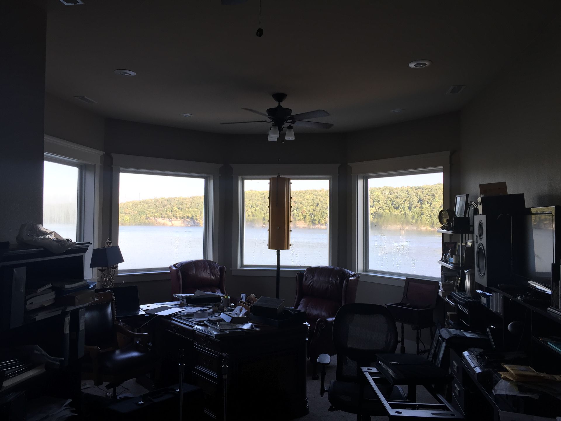 A living room with a ceiling fan and a view of a lake
