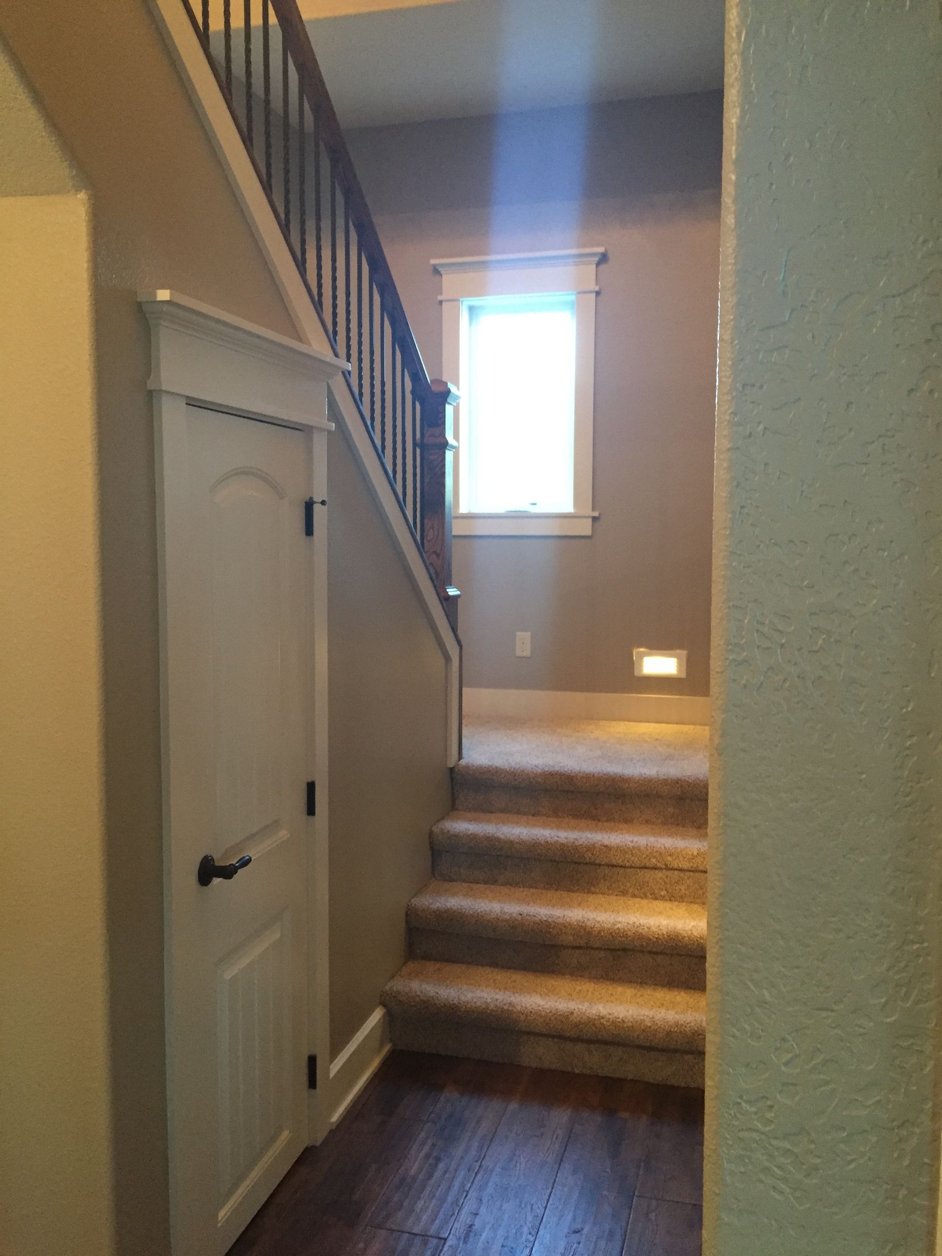 A hallway with stairs leading up to the second floor of a house.