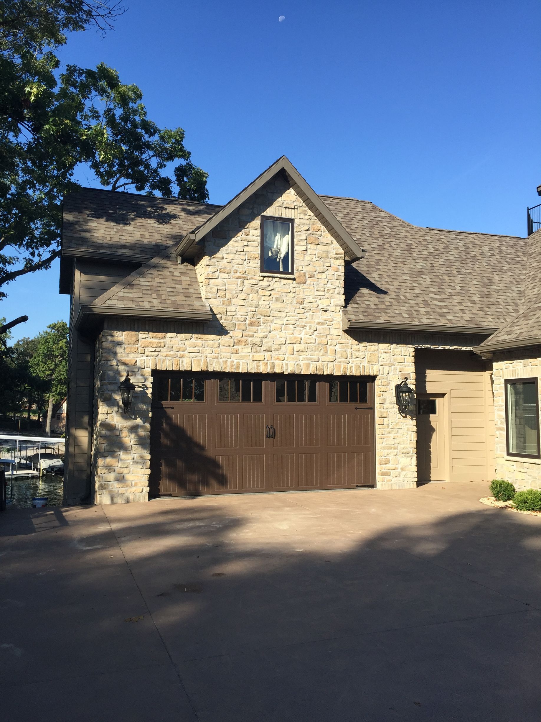 A large brick house with a brown garage door