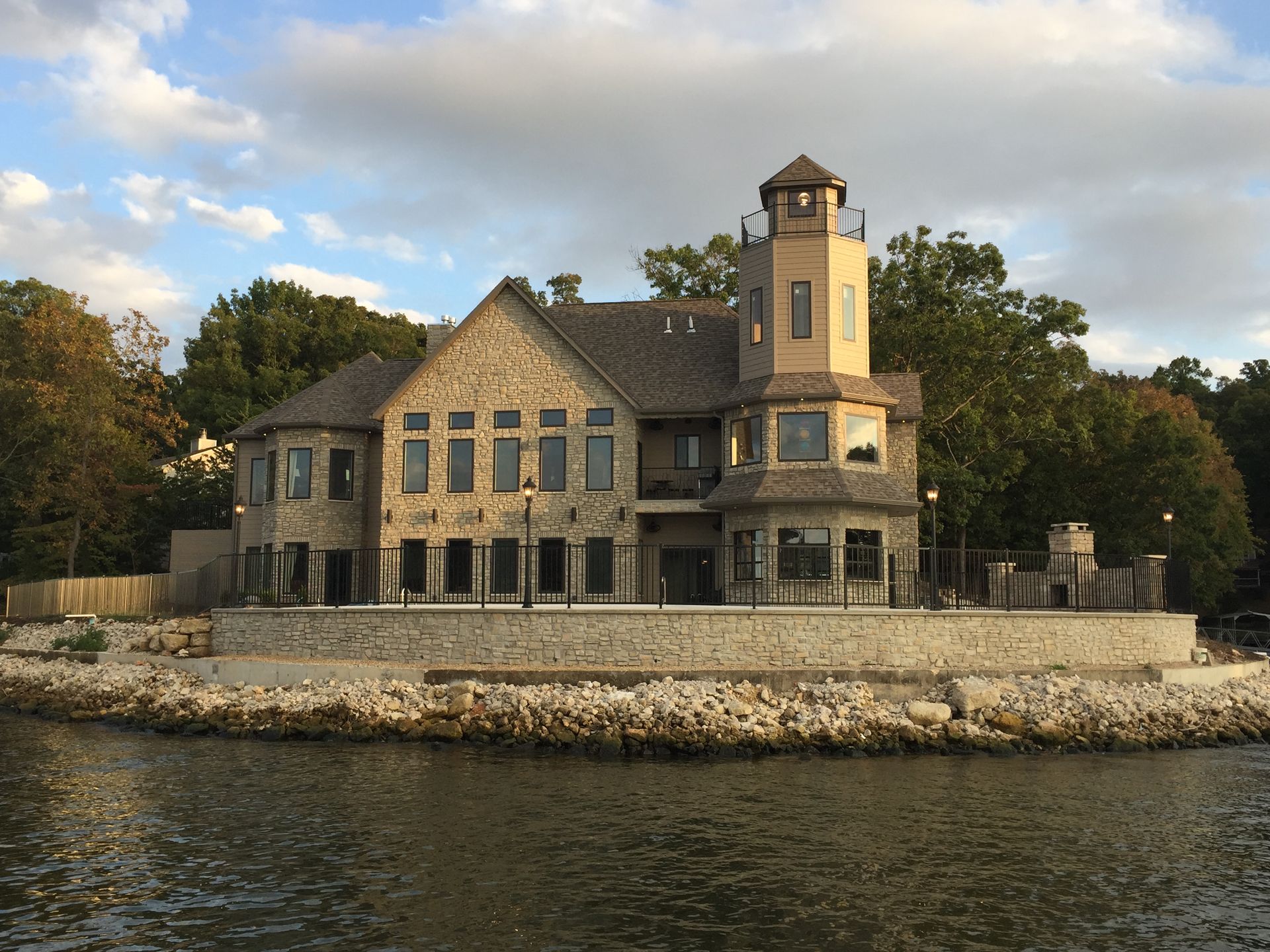A large house sits on the shore of a lake