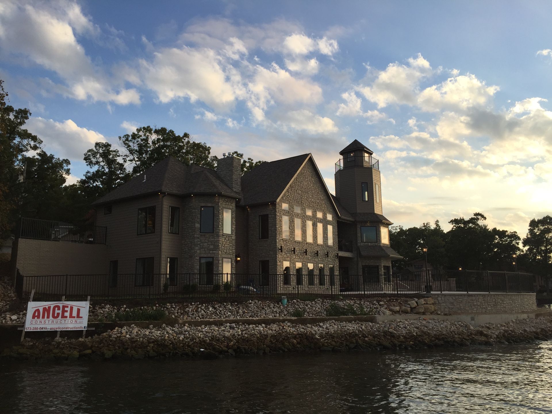 A large house sits next to a body of water