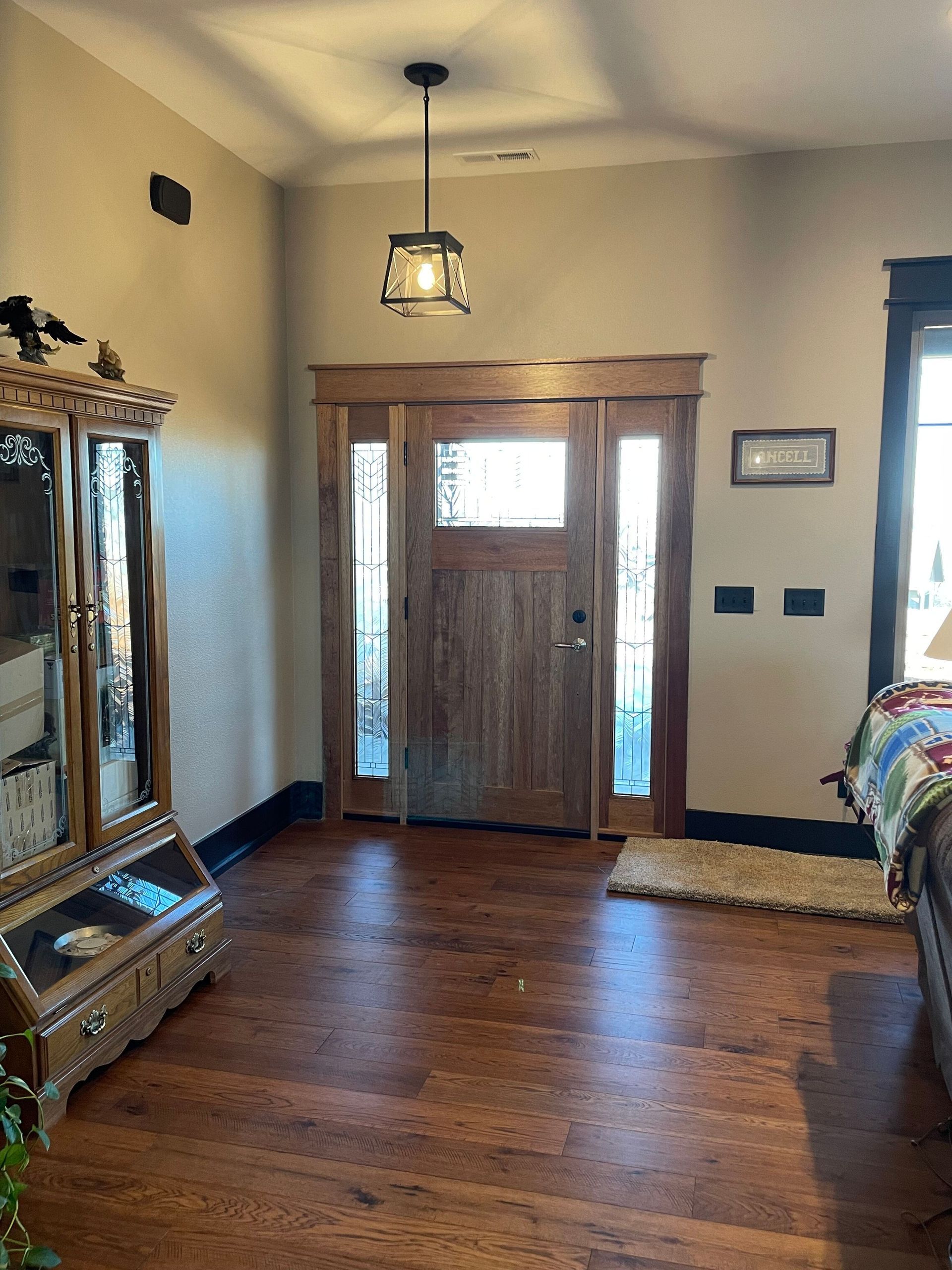 A living room with hardwood floors and a wooden door.