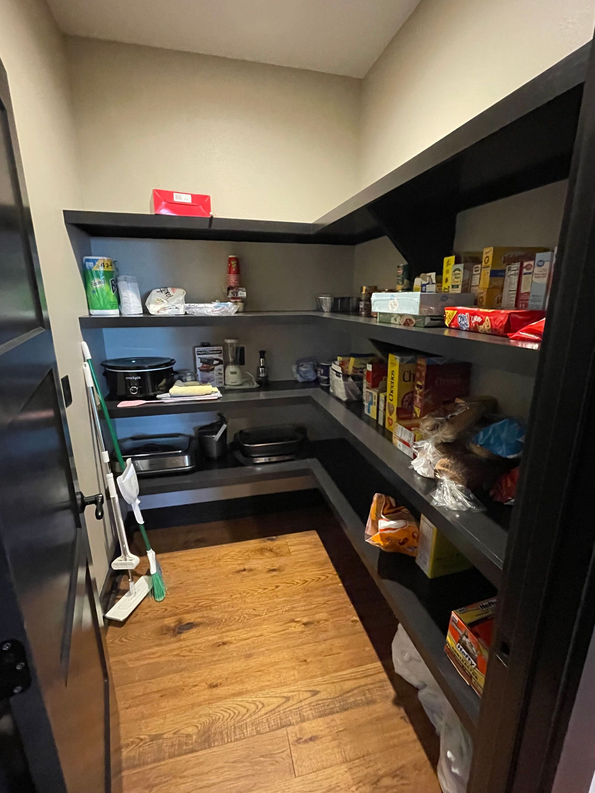 A pantry filled with lots of food and a refrigerator.