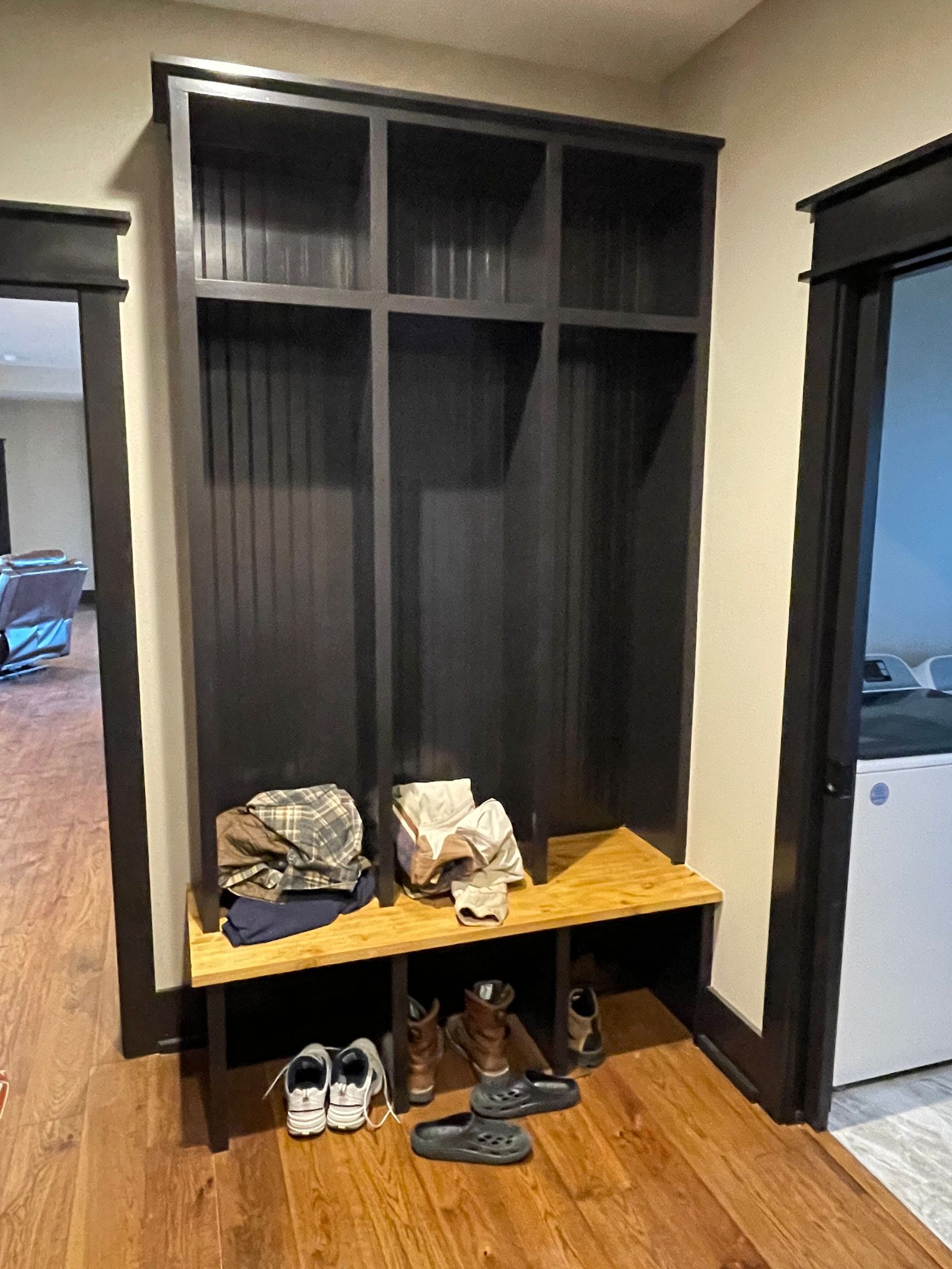 A mud room with a bench and shelves in a house.
