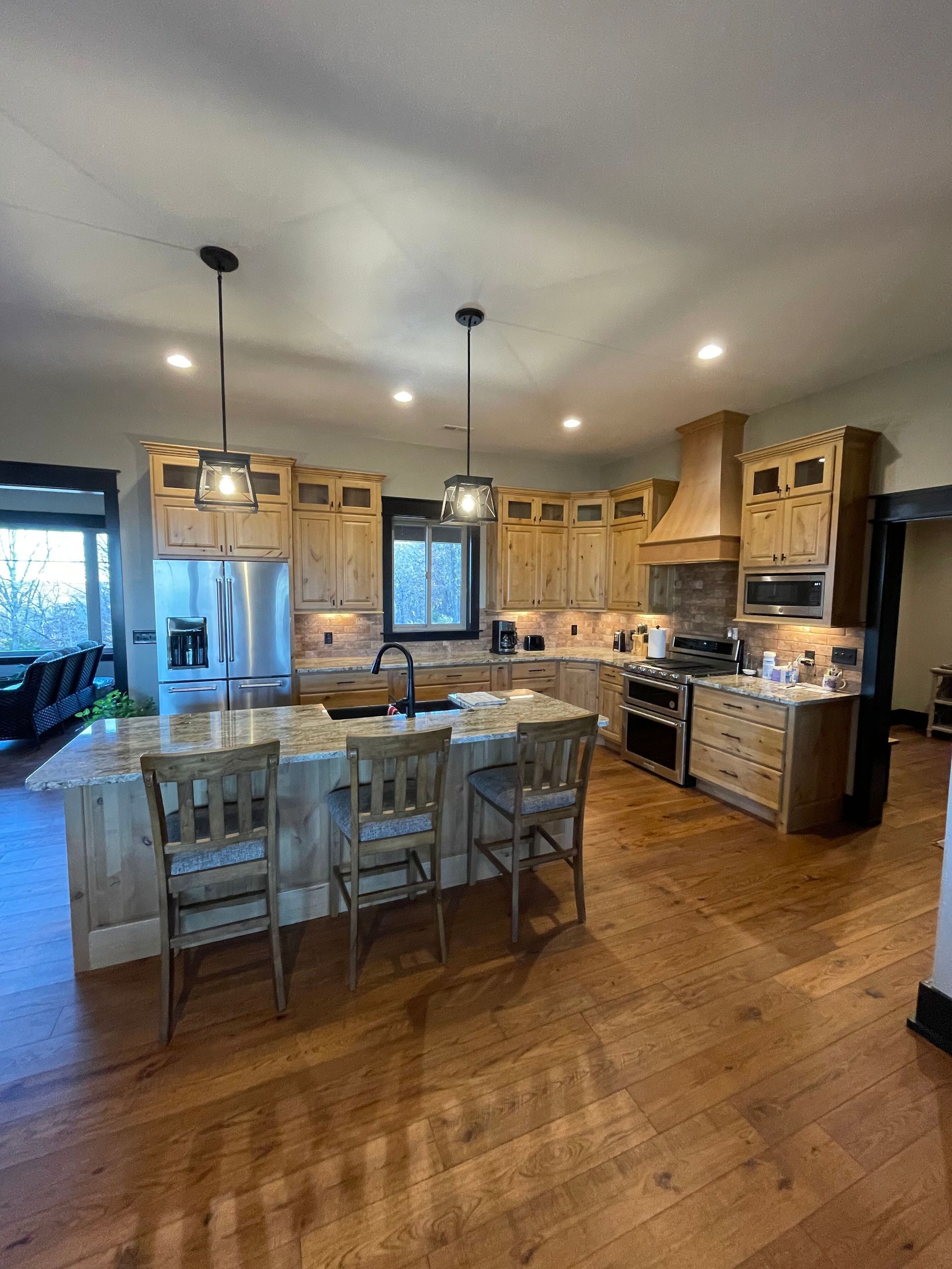 A large kitchen with stainless steel appliances and wooden cabinets.